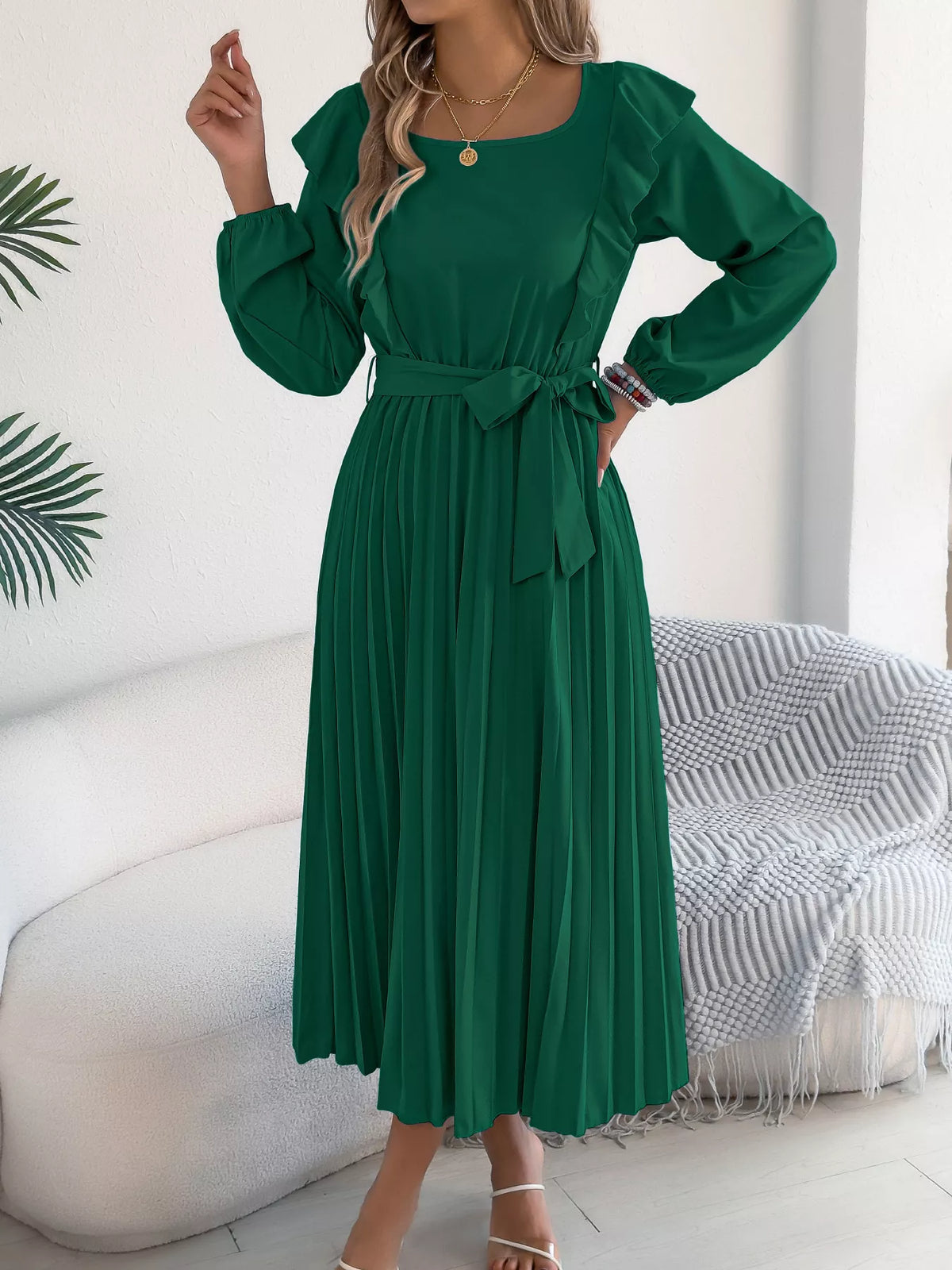 Green ruffled pleated tie-waist midi dress, front with hand at waist.
