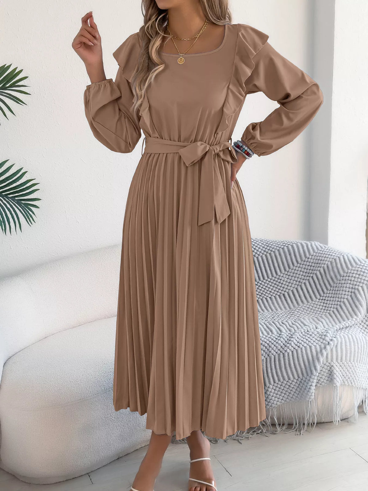 Taupe ruffled pleated tie-waist midi dress, front with hand at waist.
