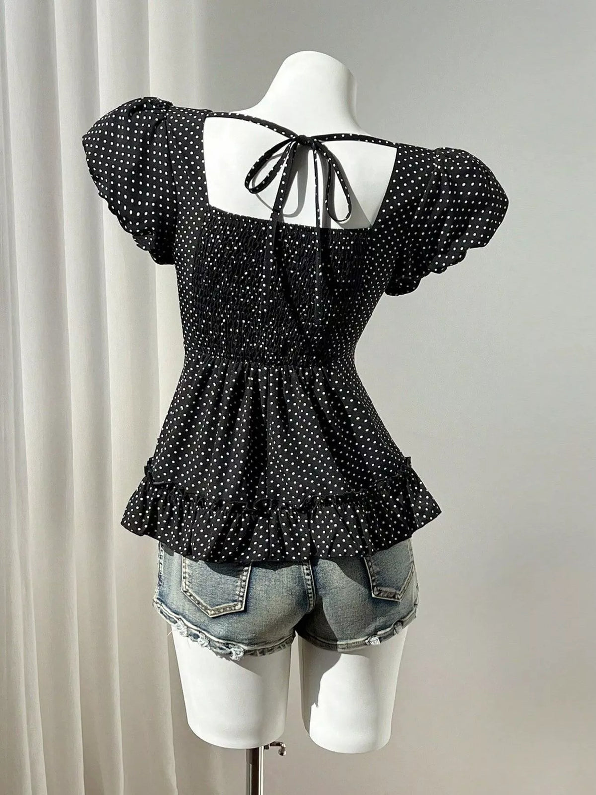 Polka-dot peplum blouse, black mannequin back
