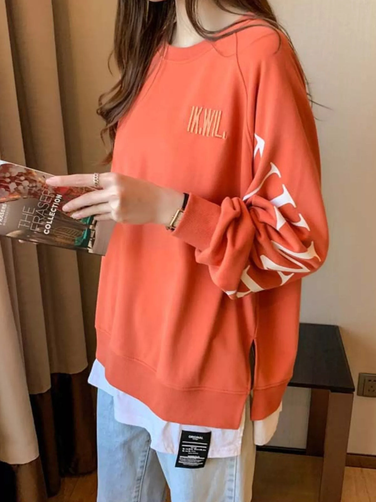 Orange layered-hem sweatshirt with graphic sleeve detail