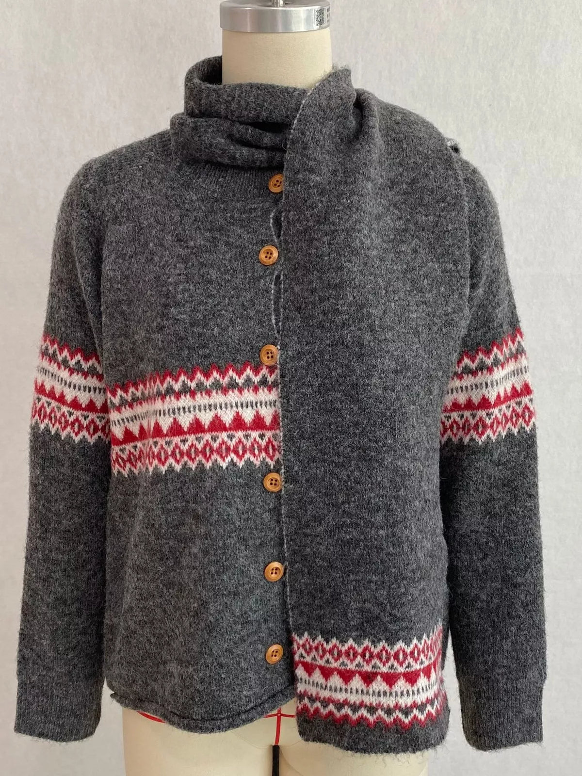 Charcoal geometric button-front knit cardigan, front on dress form with scarf.