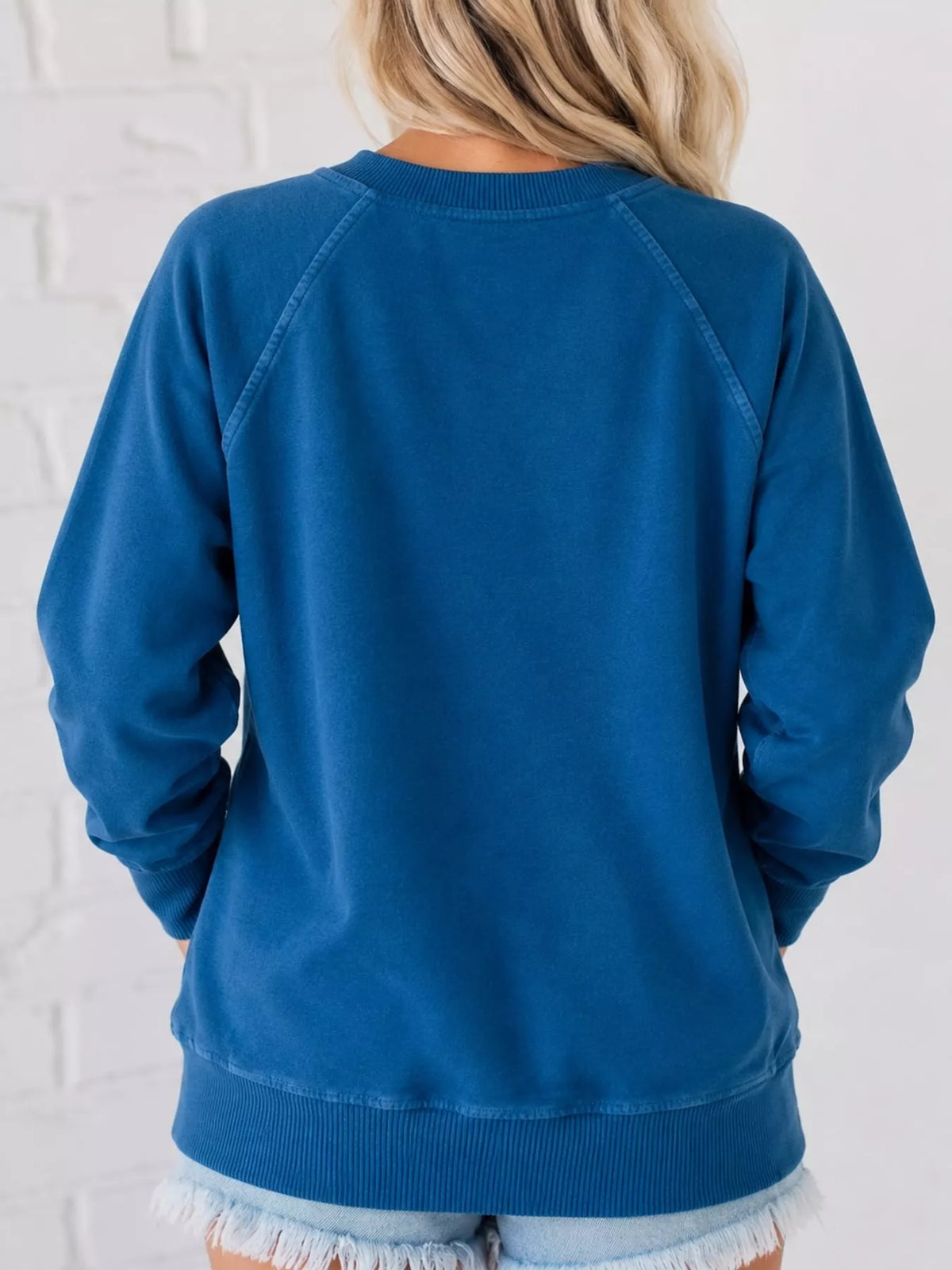 Blue crew neck raglan sleeve sweatshirt, back view