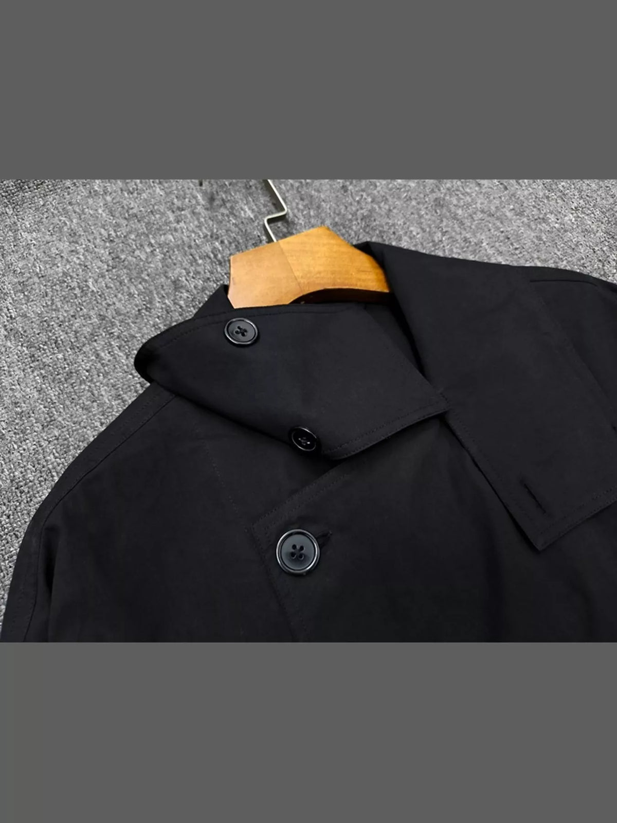 Black double-breasted utility jacket with drawstring hem — design and construction details