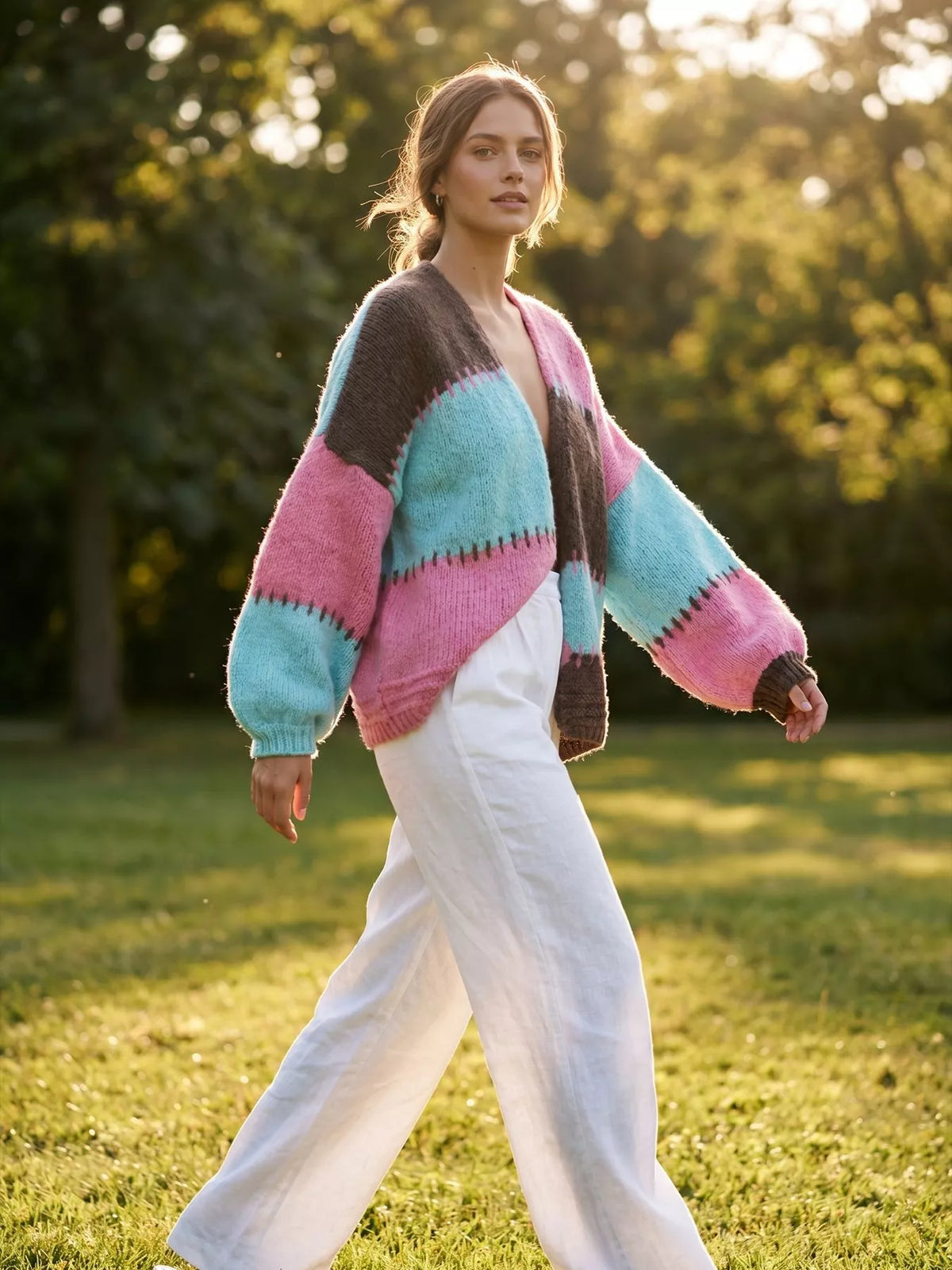 Pink and blue color-block v-neck cardigan, walking side view.