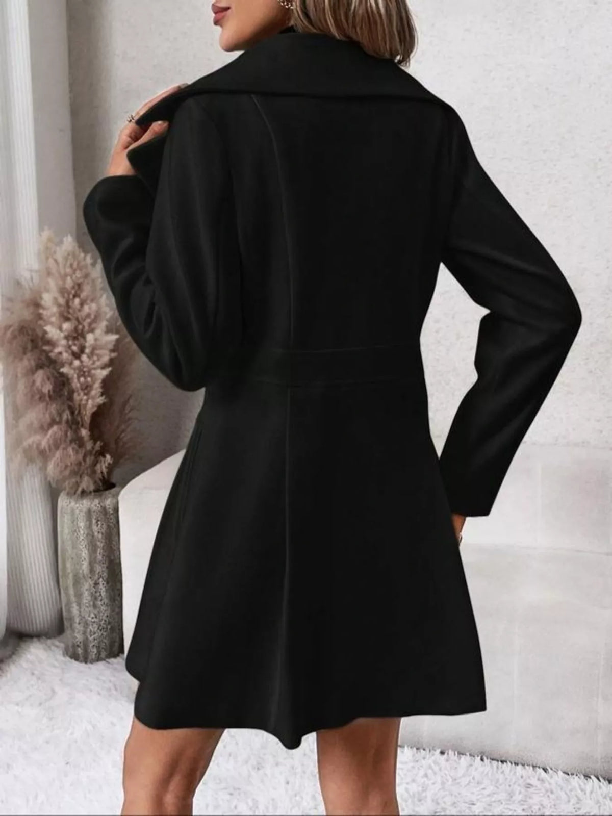 Black double-breasted peplum coat, back view