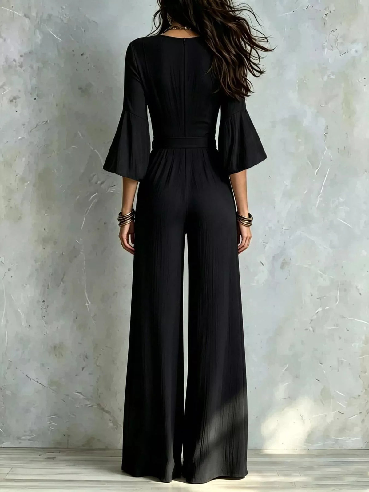 Black pleated wide-leg jumpsuit with tie-waist, back view
