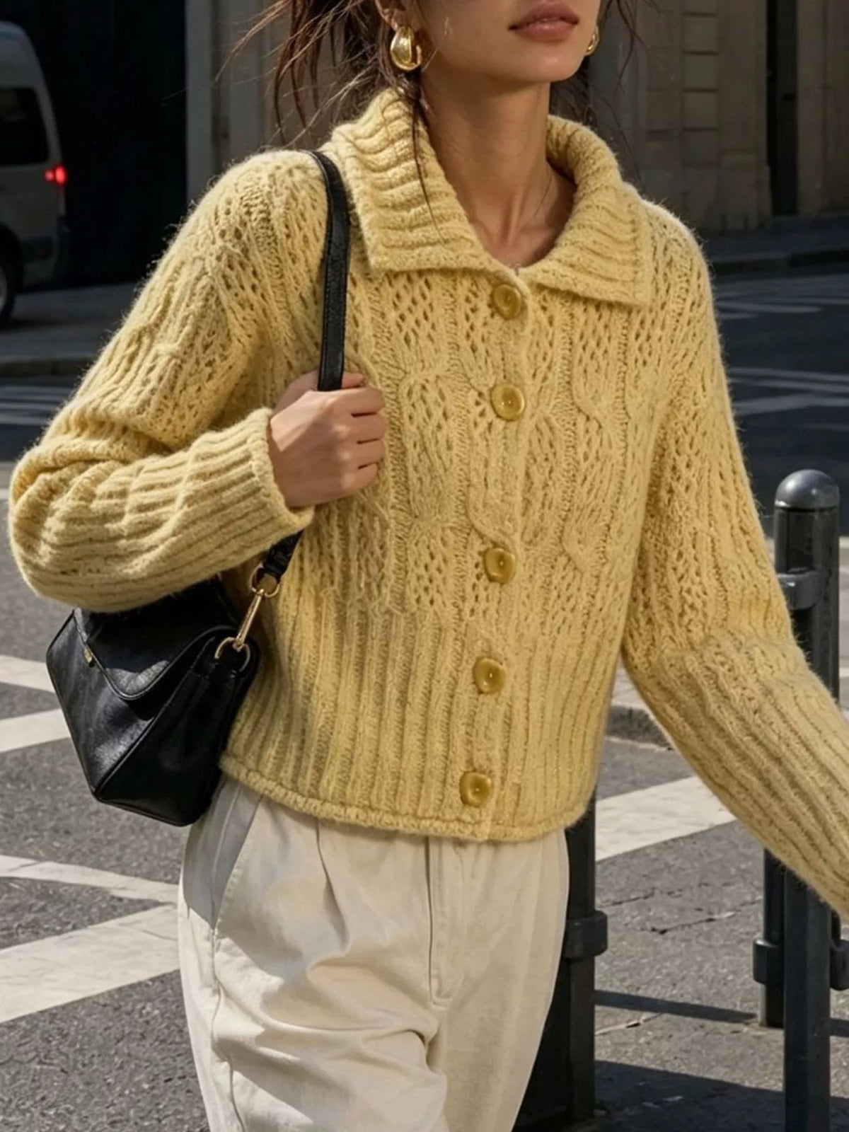 Yellow cable-knit collared button-front cardigan, walking front view.