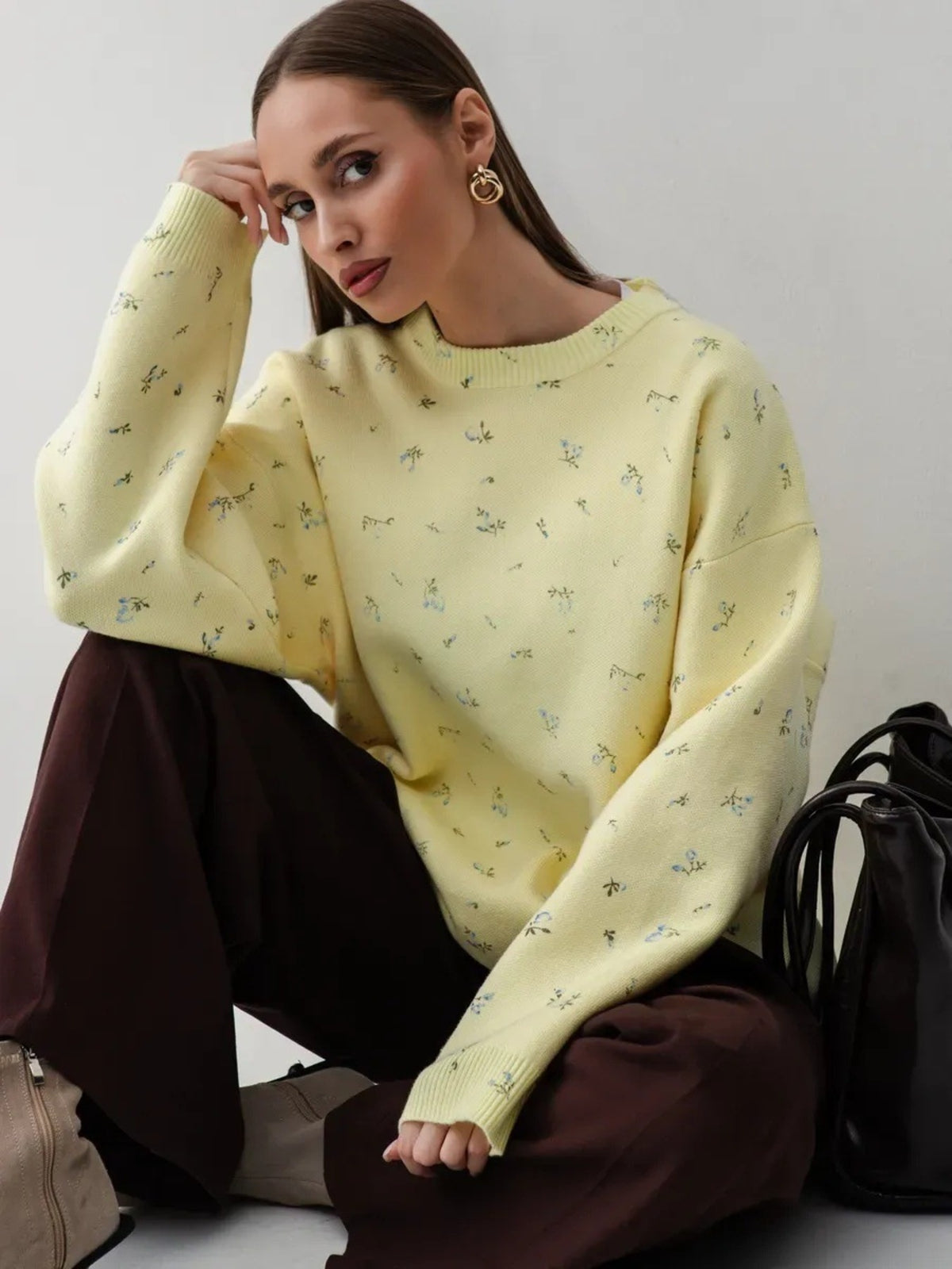 Yellow floral dropped-shoulder oversized sweater, seated front view.