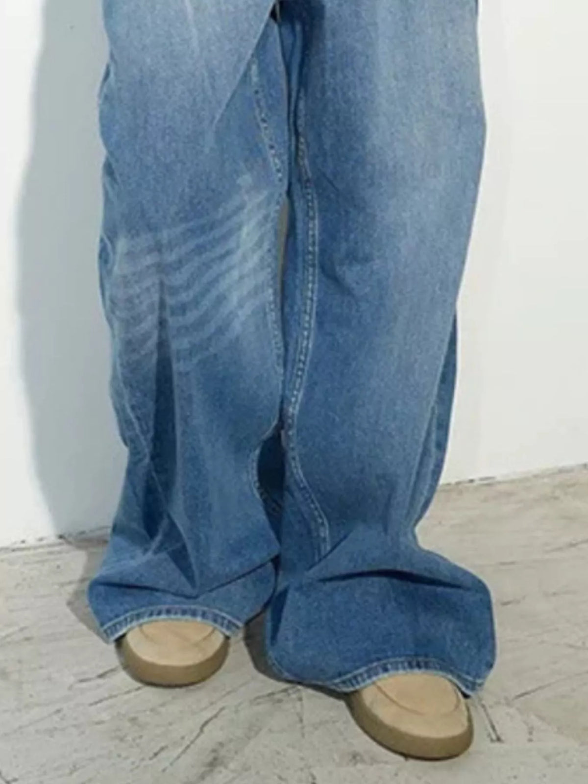 Blue high-waisted distressed wide-leg jeans, wide-leg hem detail.
