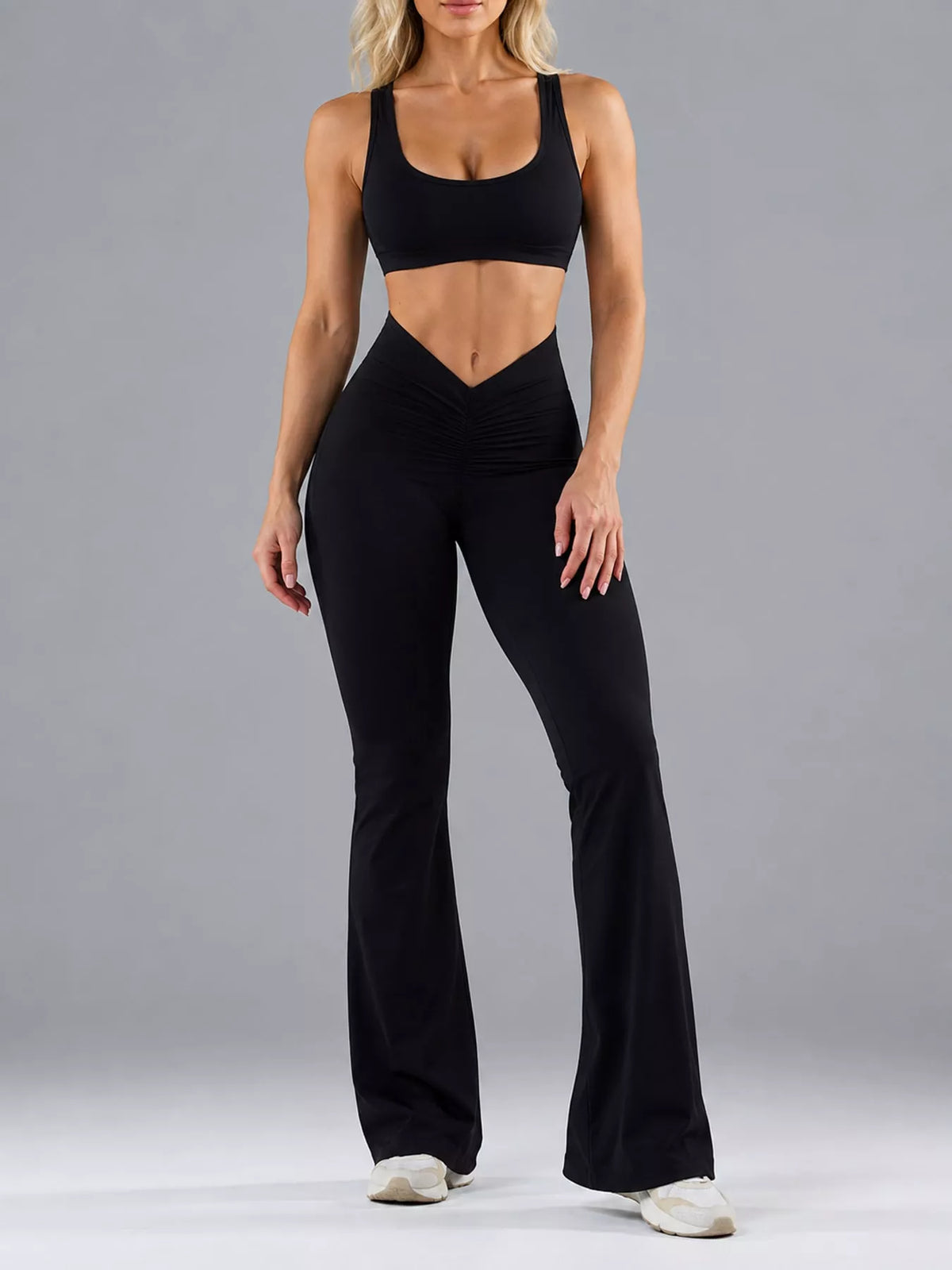 Black scoop-neck flared-leg active jumpsuit, cutout side shown facing forward.
