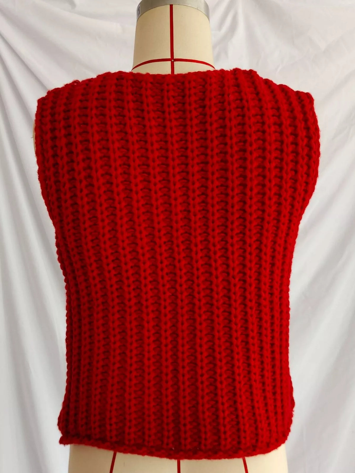 Red button-front knit sweater vest, back on dress form.