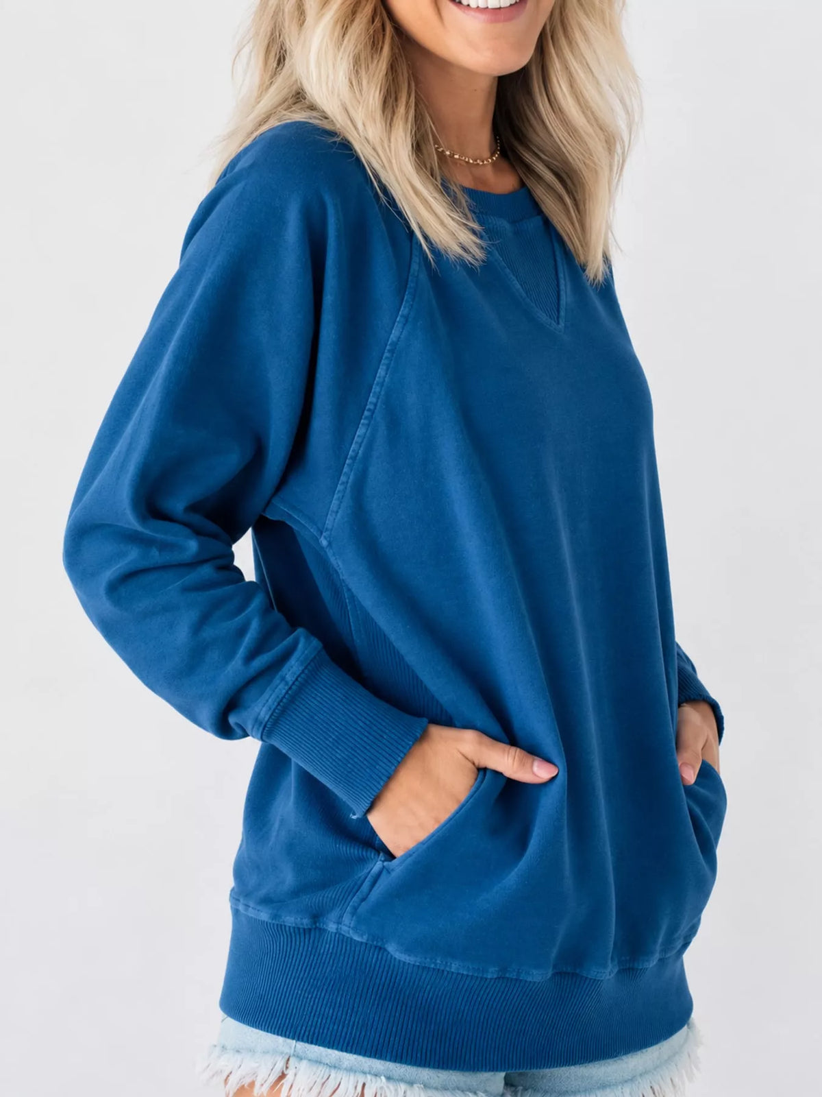 Blue crew neck raglan sleeve sweatshirt, side view