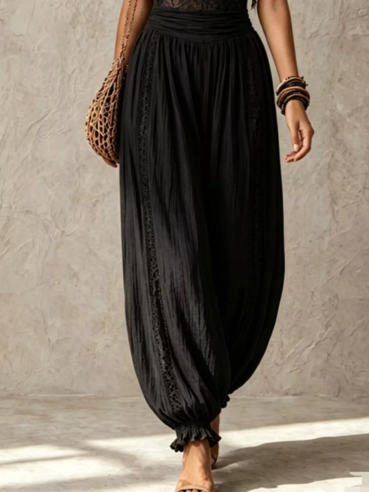 Black lace-bodice harem-leg jumpsuit, harem pants detail.