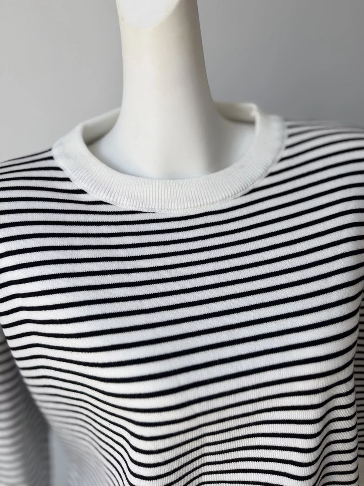 Striped round-neck knit top in white and black, neckline detail