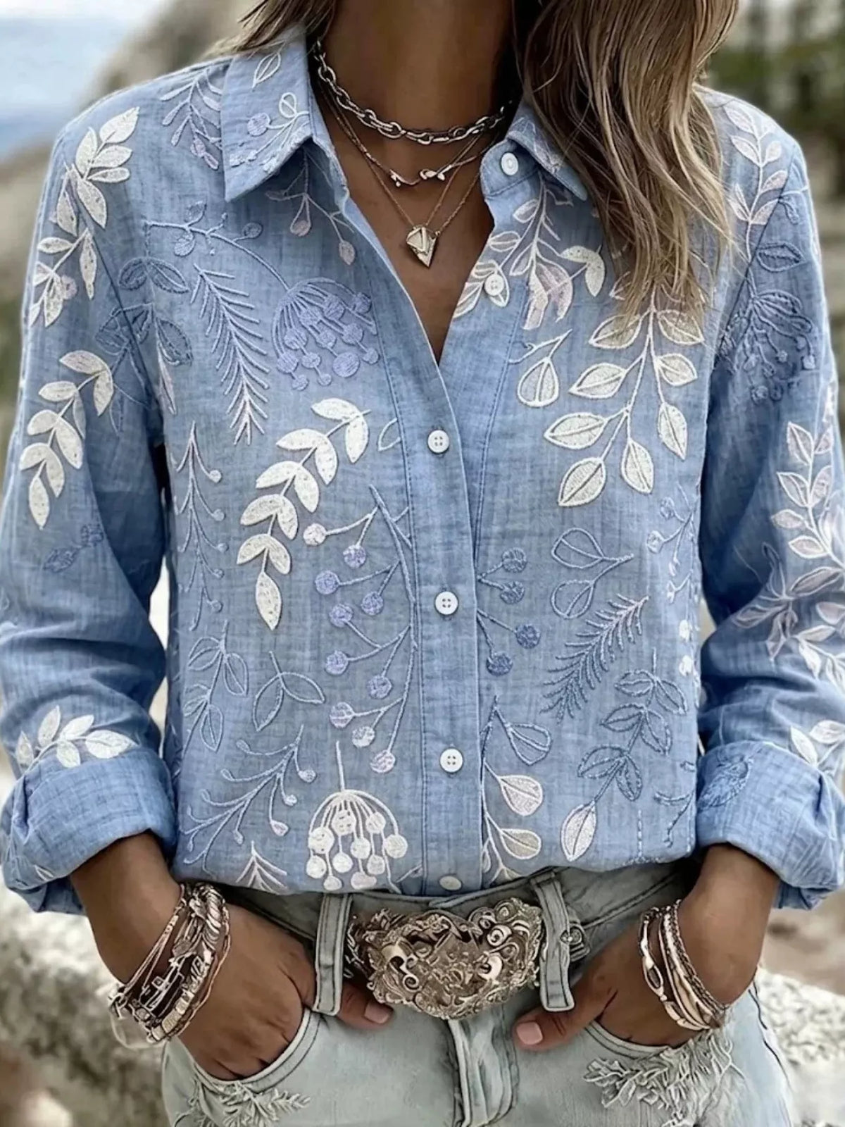 Blue leaf-embroidered button-down shirt, front view.