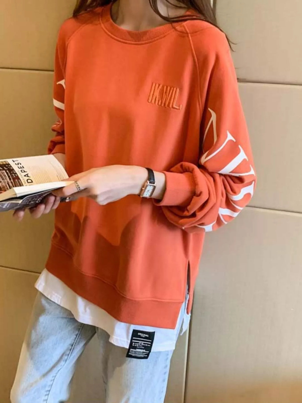 Orange layered-hem sweatshirt with graphic sleeve detail