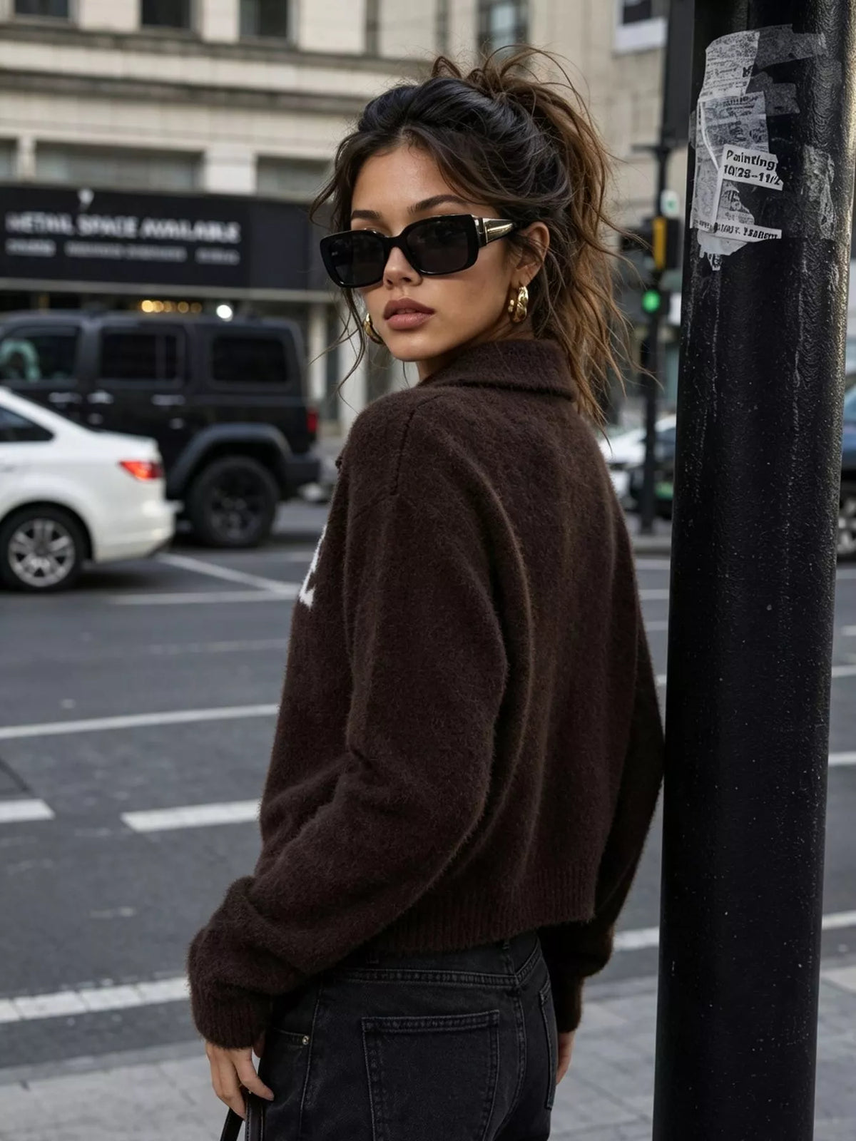 Brown fuzzy letter zip-up cardigan, back view.