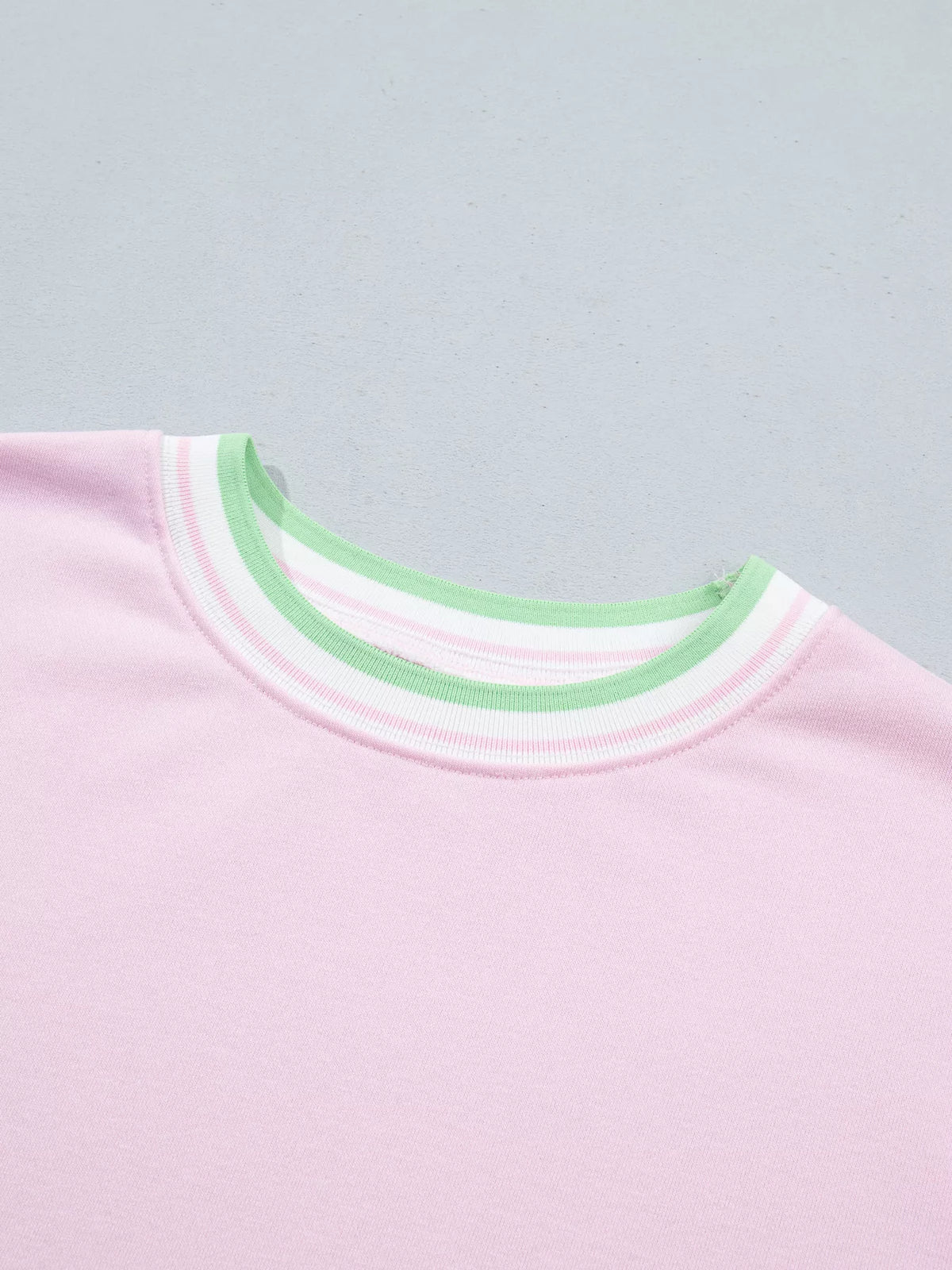 Pink sweatshirt with contrast striped ribbed trim, neckline detail