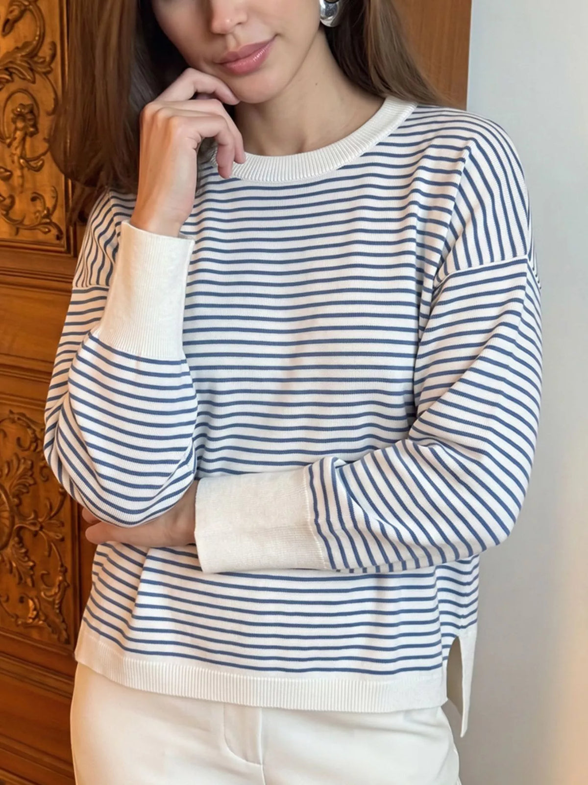 Striped round-neck knit top in white and blue, sleeve detail on model