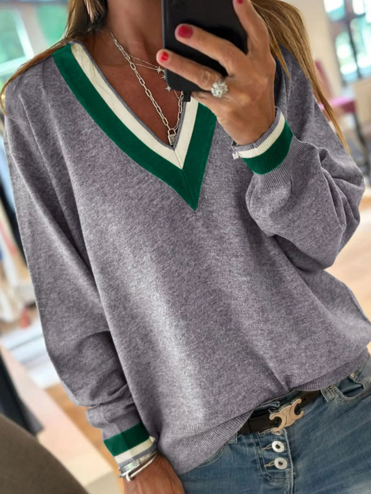 Gray v-neck sweater with striped trim, neckline detail.