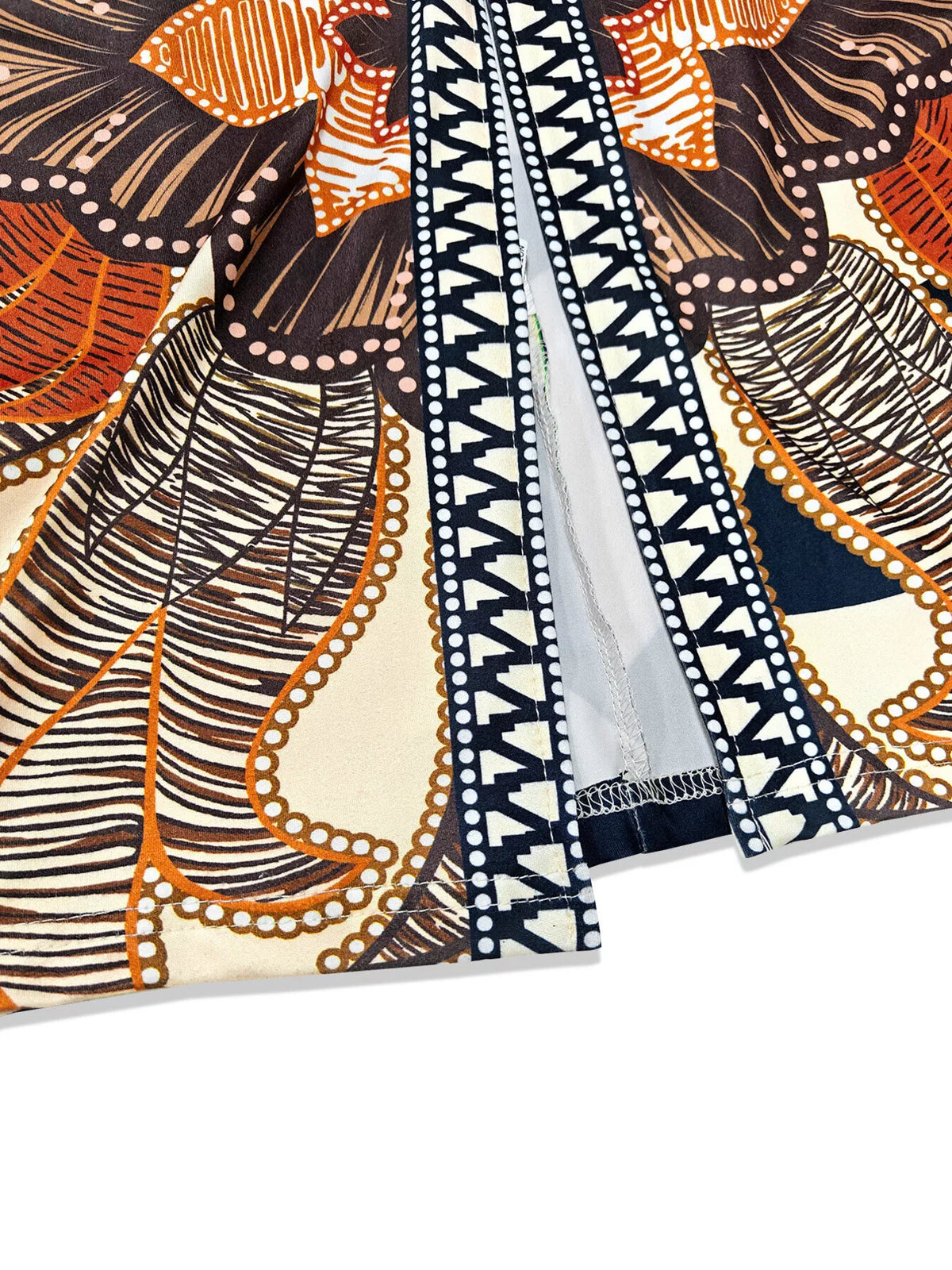 Orange, black and cream printed slit long-sleeve dress, front slit and trim close-up