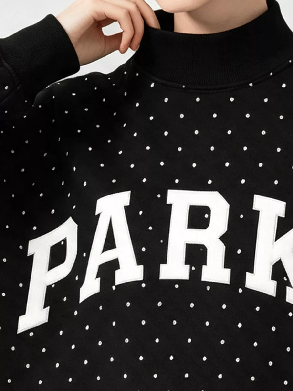 Black polka dot letter graphic sweatshirt, neckline and lettering detail