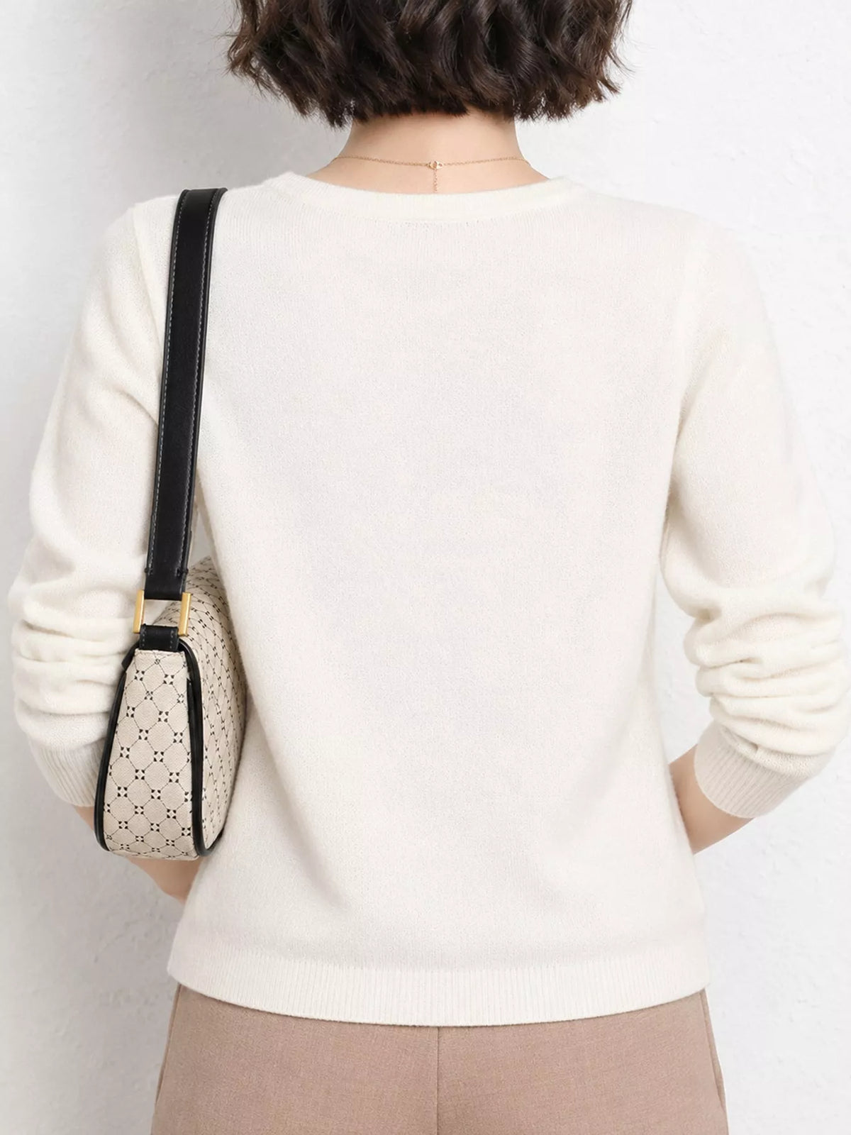 White v-neck long sleeve knit top, back view