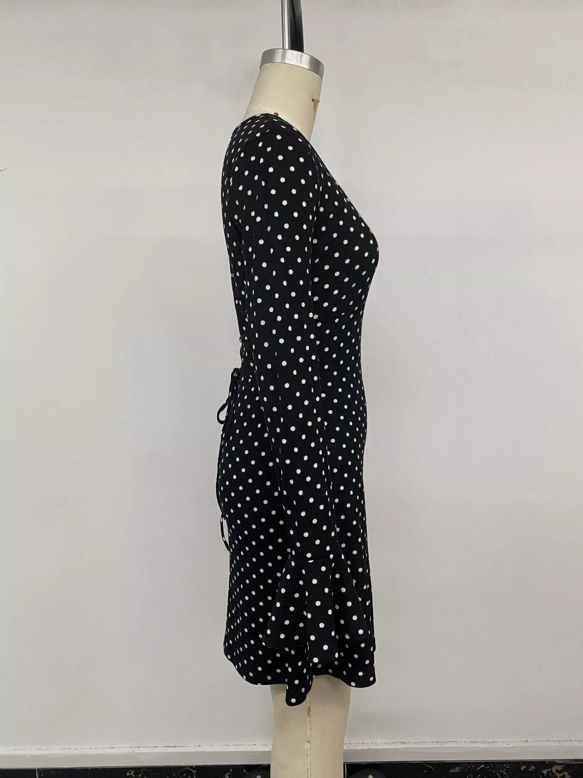 Black polka dot flounce sleeve mini dress, side on mannequin