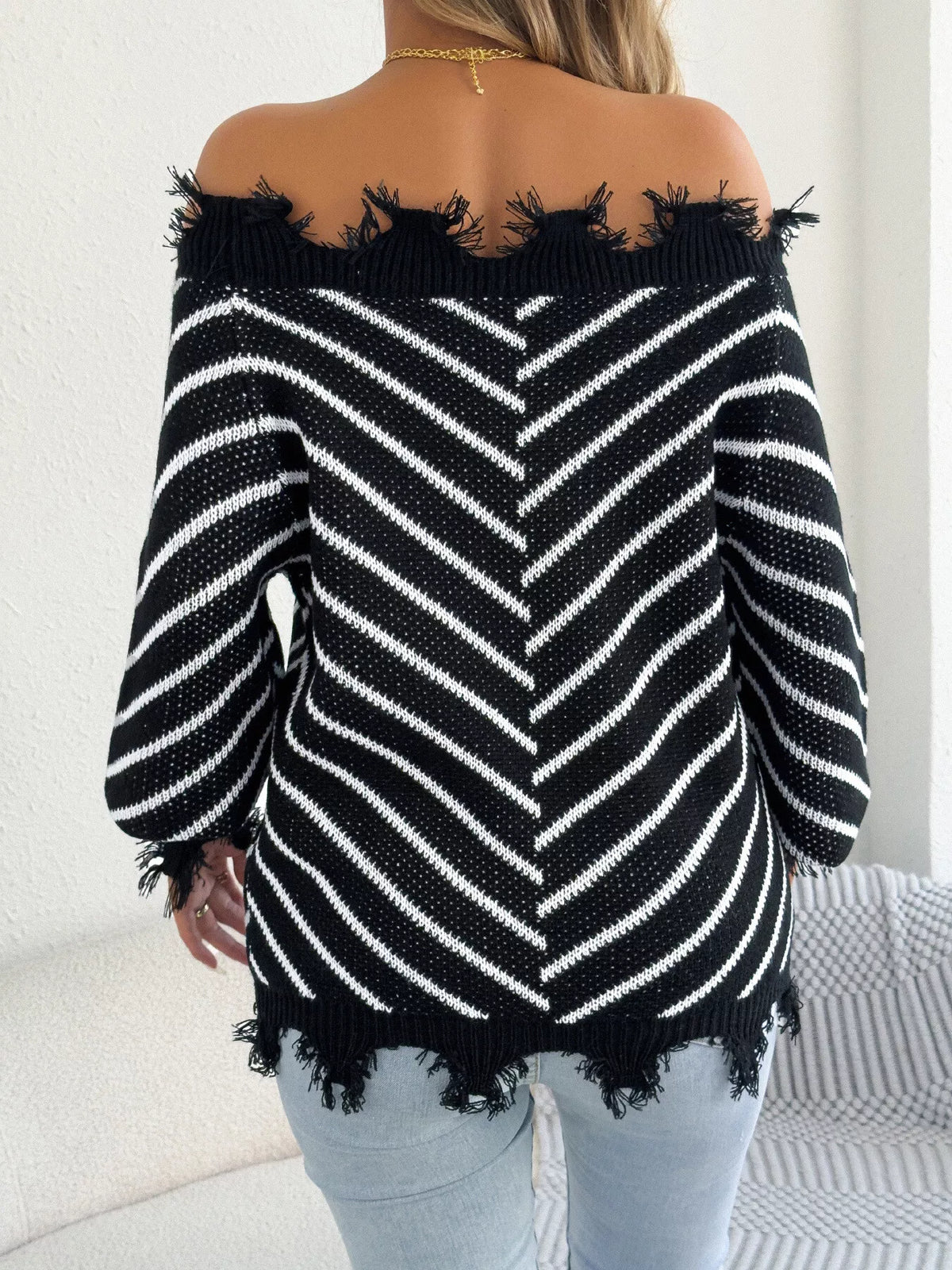 Black off-shoulder distressed striped sweater, back view