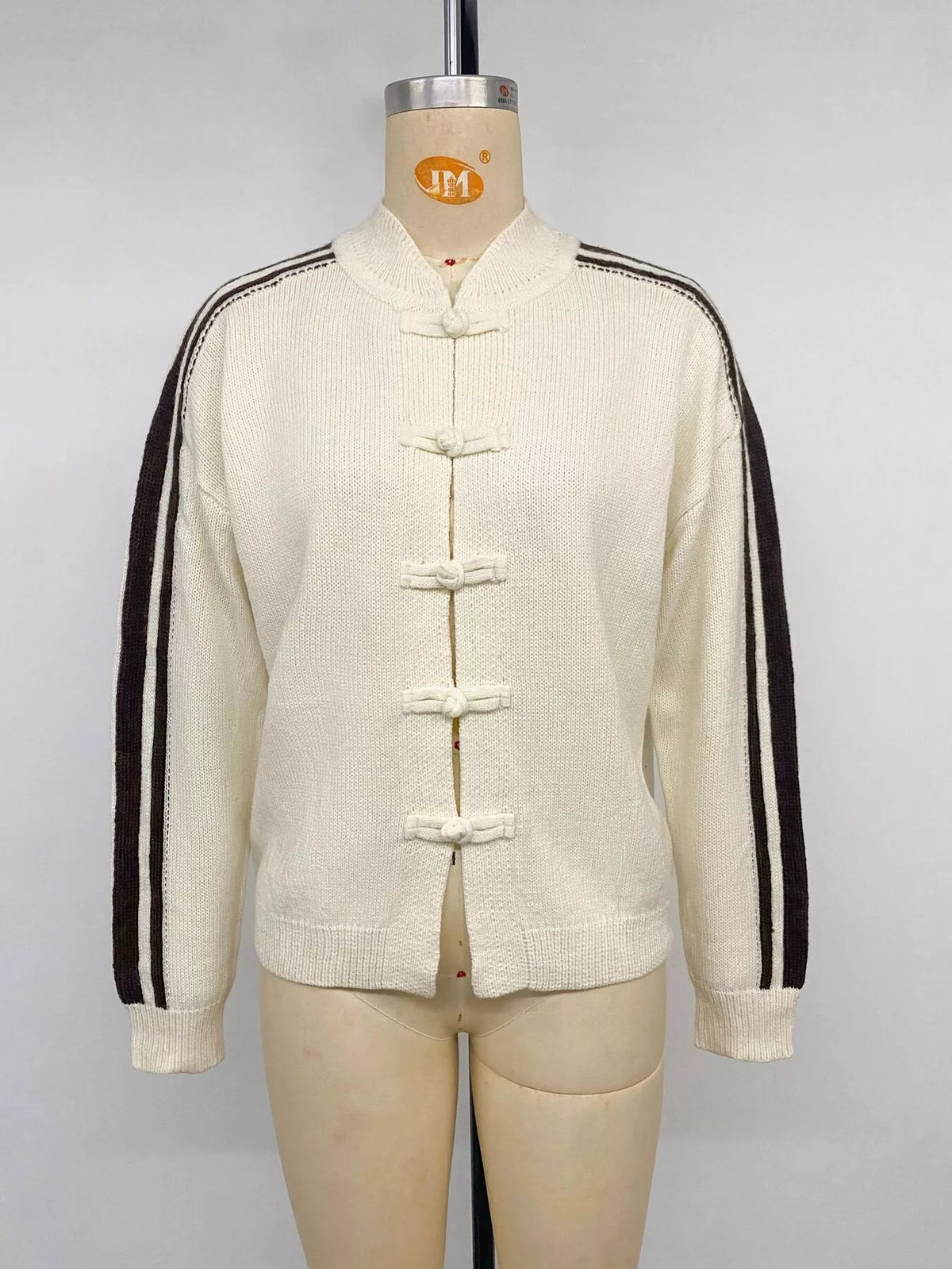 Cream Chinese knot button cardigan with sleeve stripes, front on mannequin