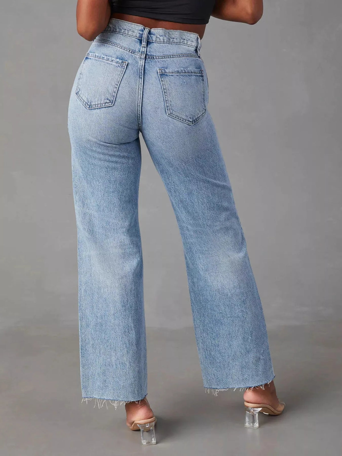 Blue high-waisted distressed jeans, back view