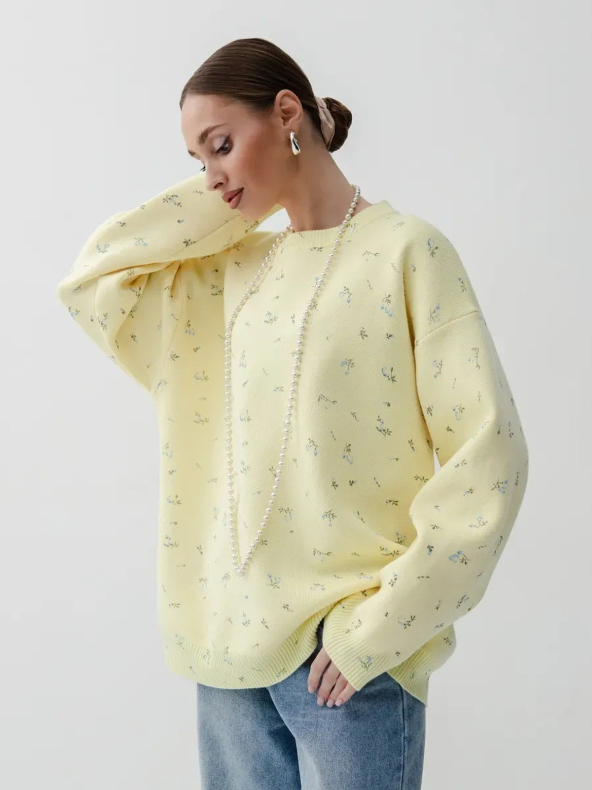 Yellow floral dropped-shoulder oversized sweater, front with hand in pocket.