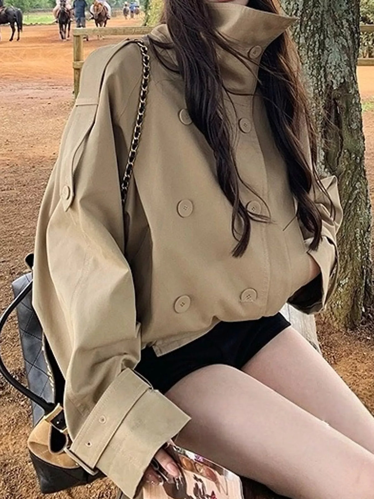 Beige double-breasted cropped trench jacket, seated front view