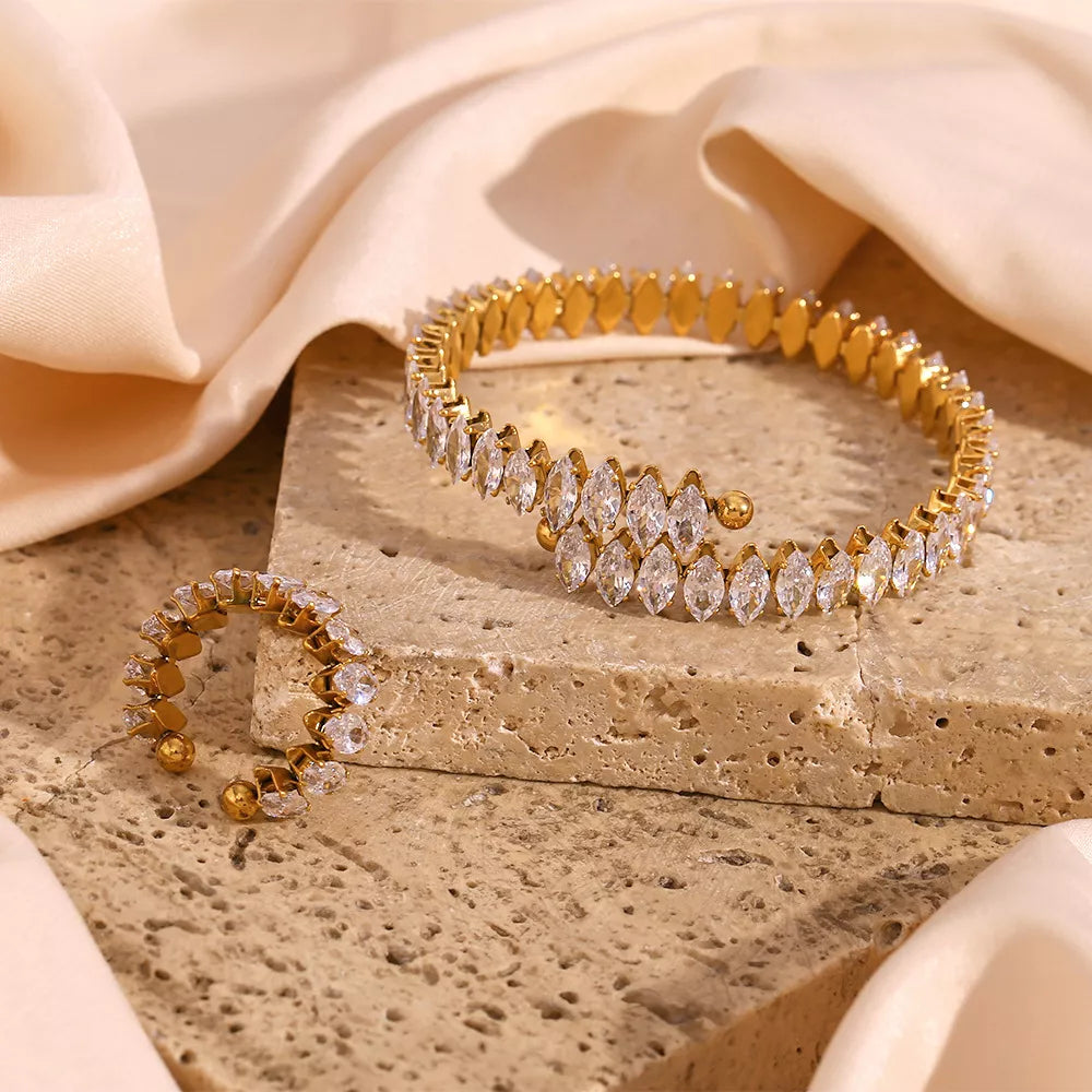 Gold-plated zircon bracelet and ring set — bracelet and ring arranged on stone