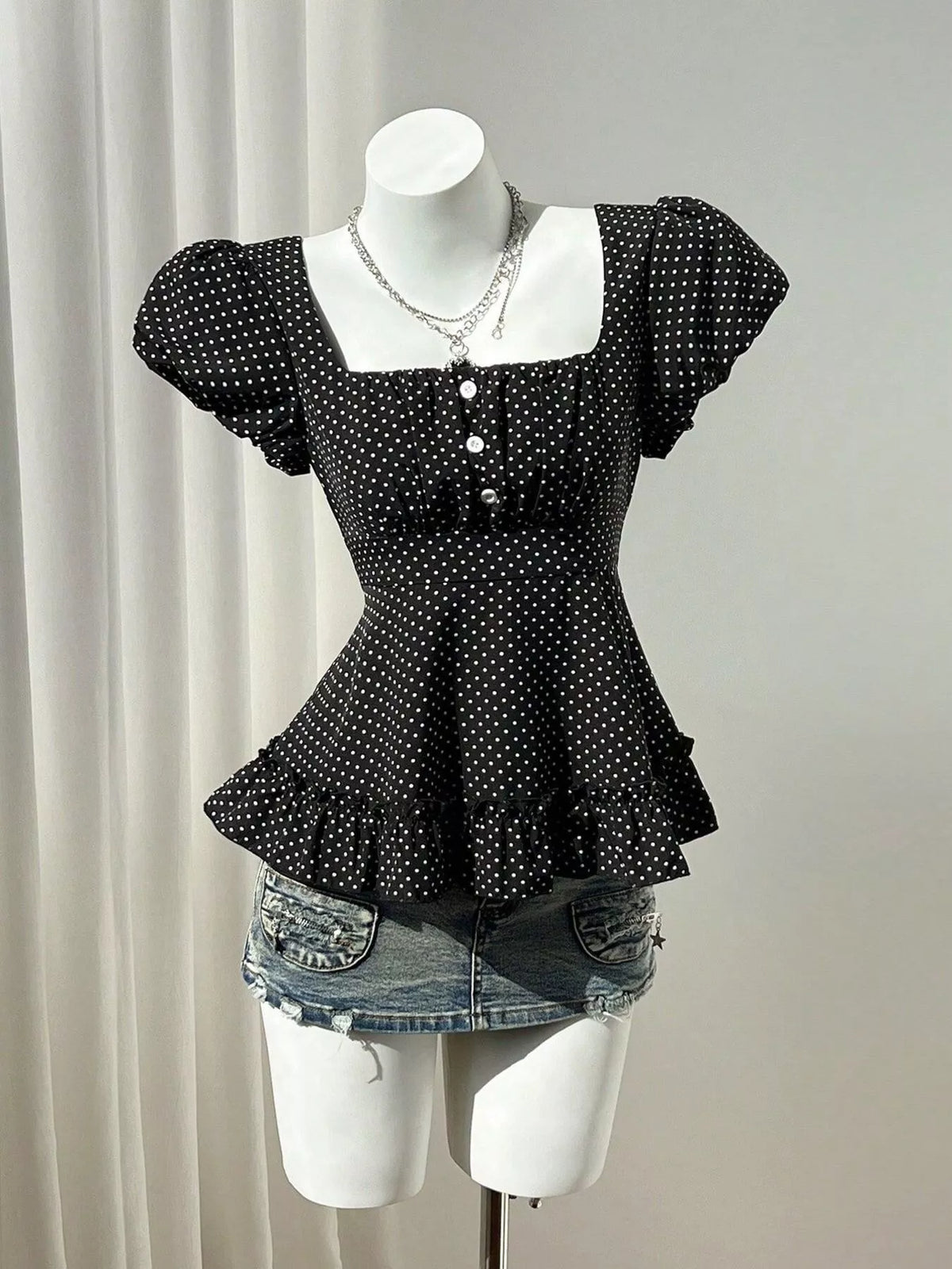 Polka-dot peplum blouse, black mannequin front