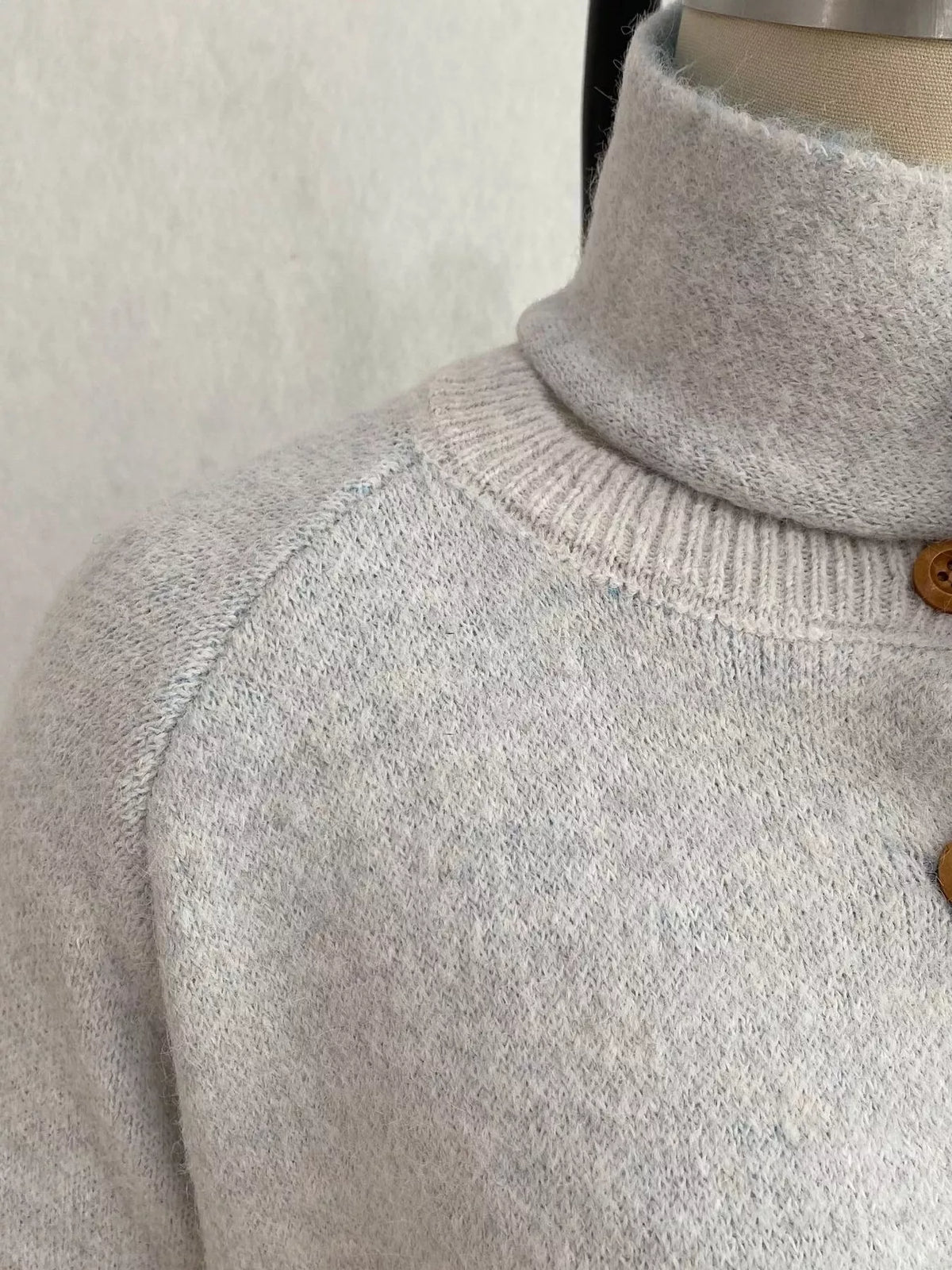 Light gray geometric button-front knit cardigan, neckline and shoulder knit detail.