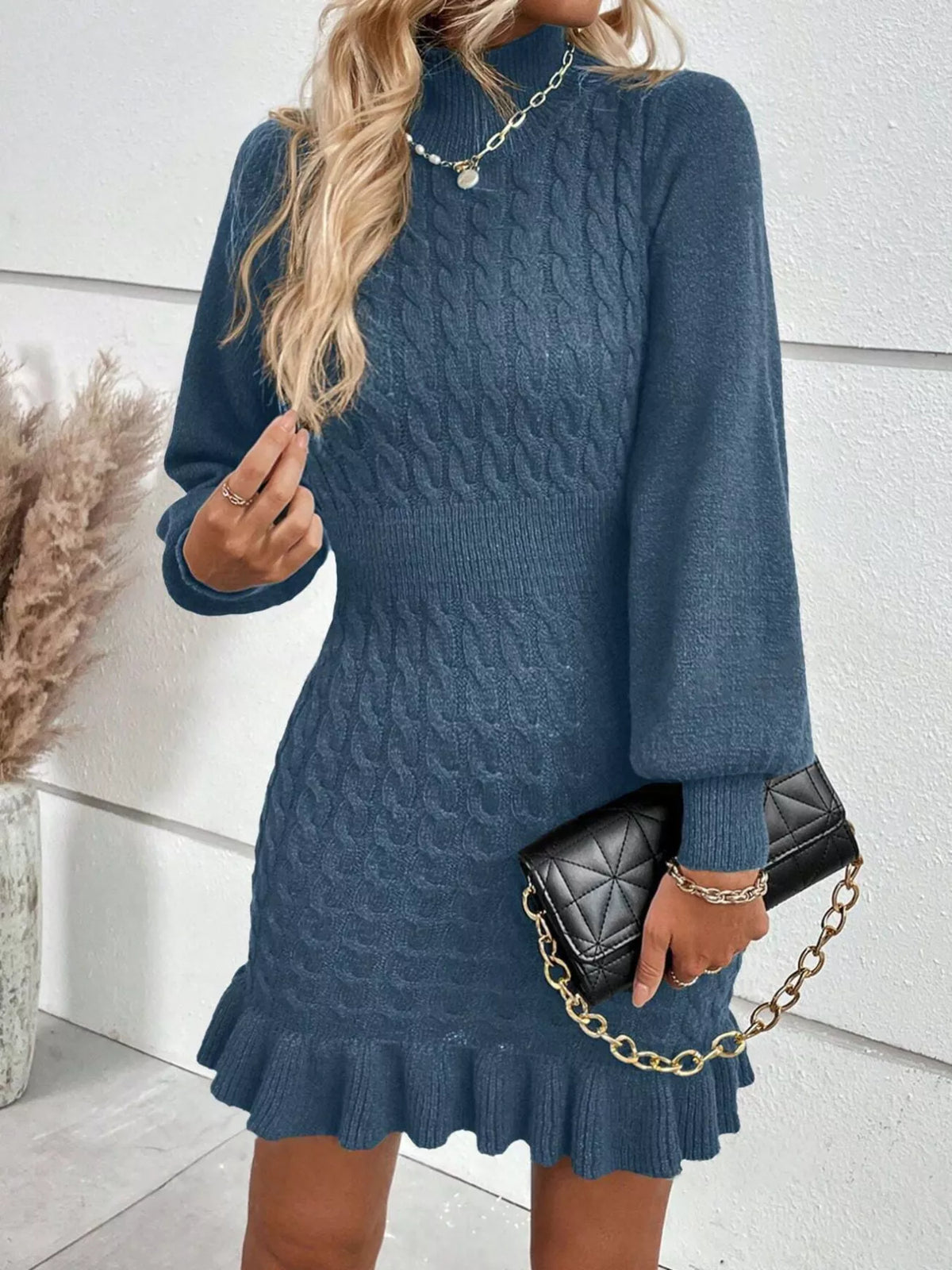 Blue cable-knit ruffle-hem sweater dress, front view.