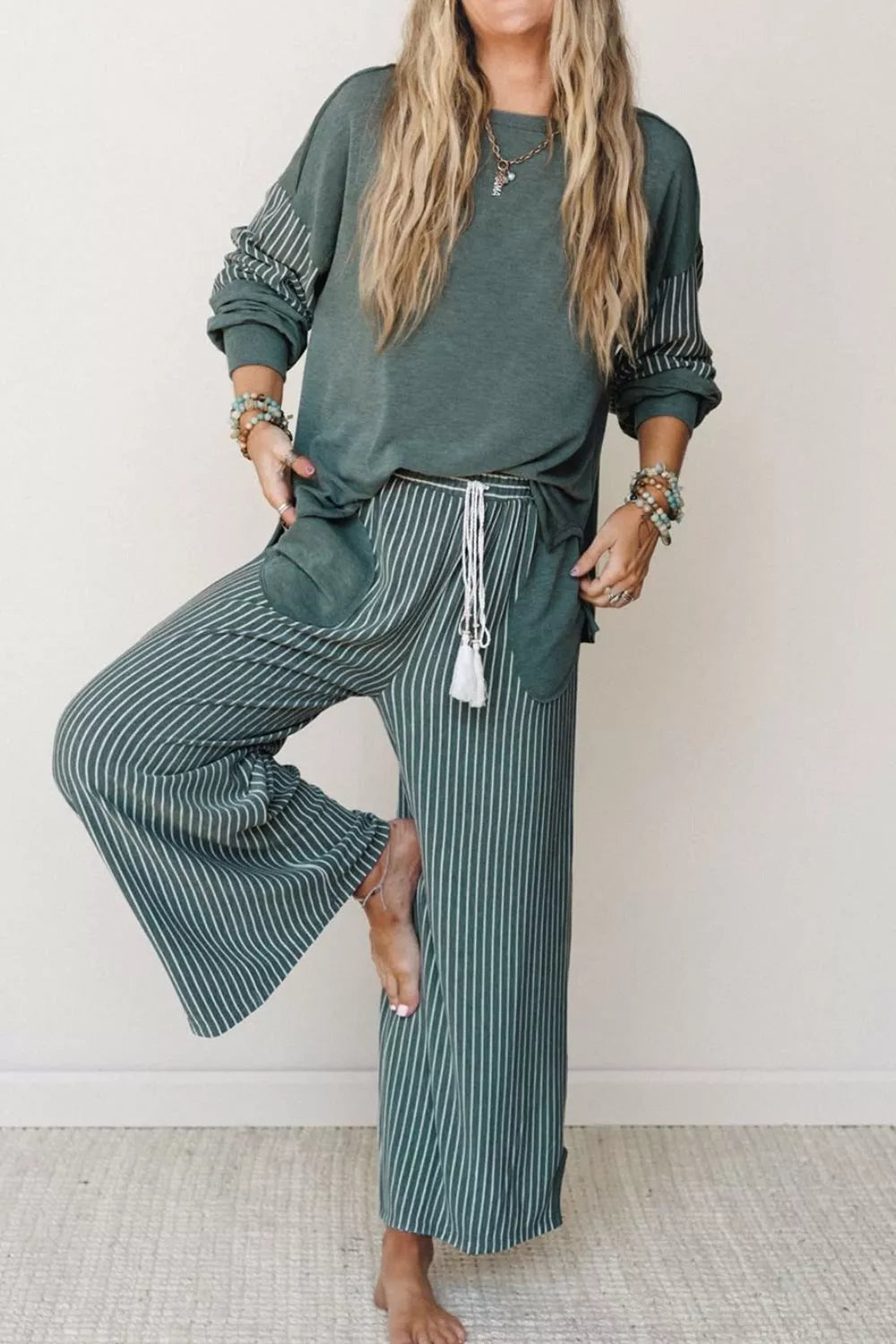 Green raw-seam top and striped pants set, front view