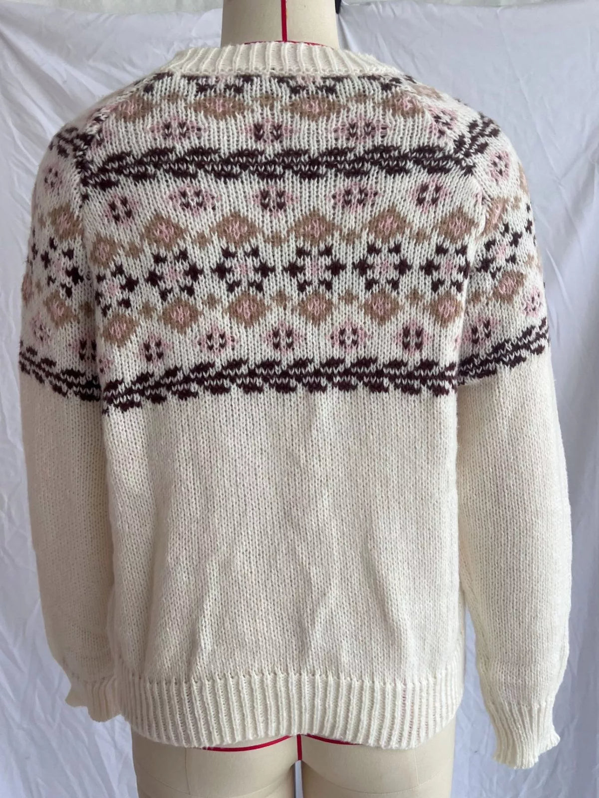 Cream fair isle round-neck sweater, back on dress form.