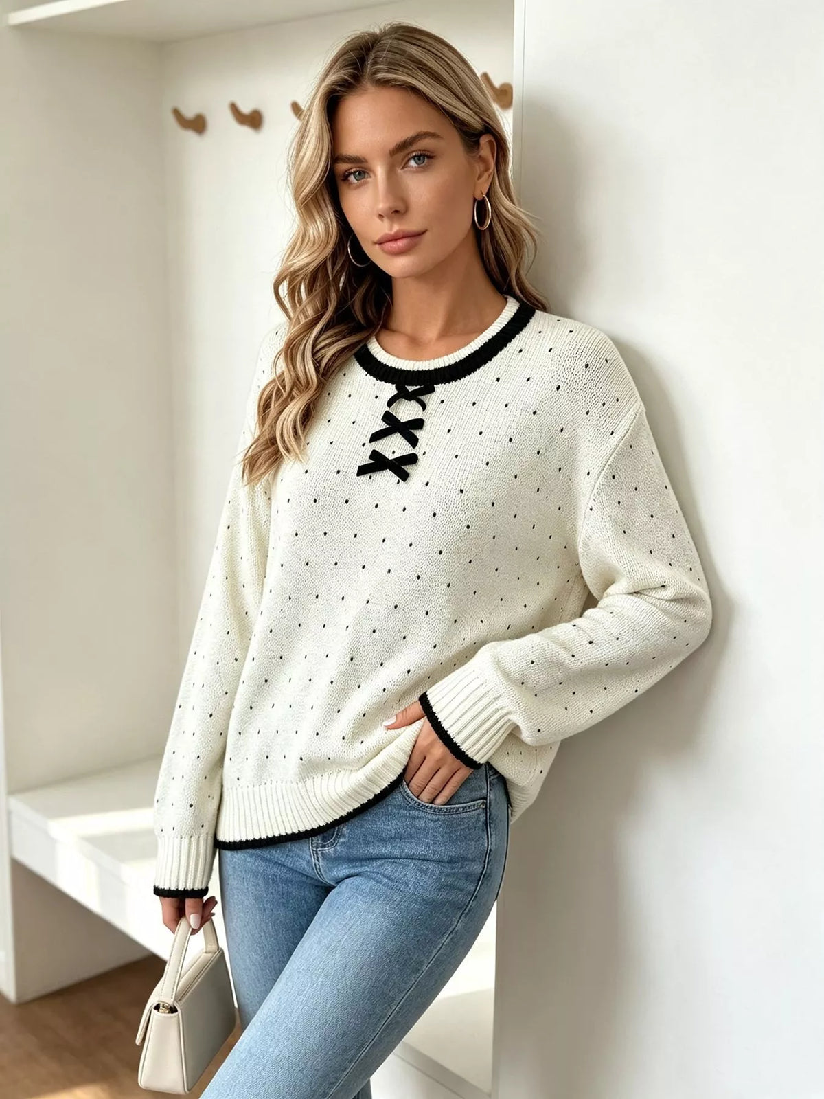 White and black polka dot lace-up sweater, angled front view.