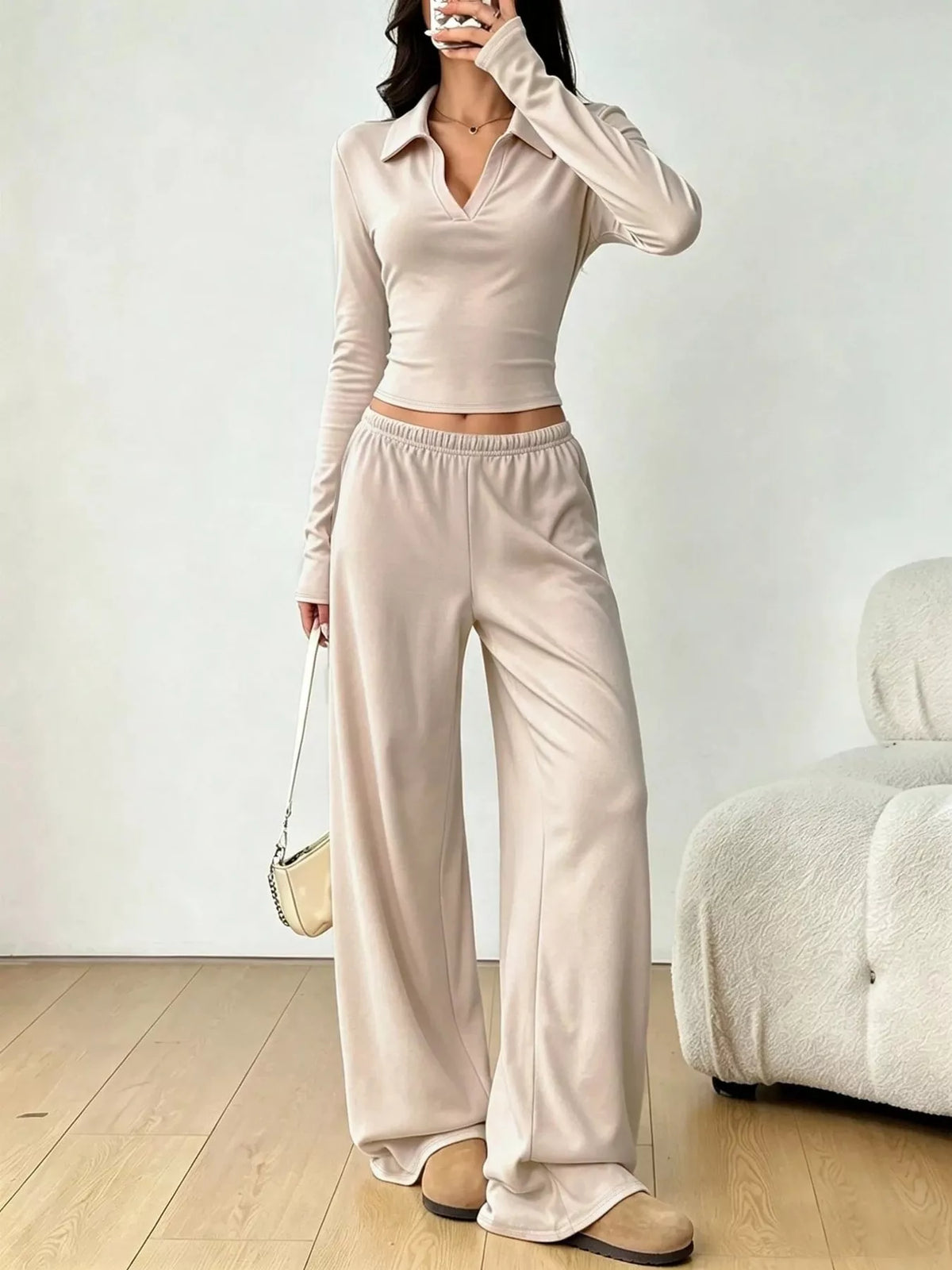 Beige collared crop top and wide-leg pants set, front view with hand raised