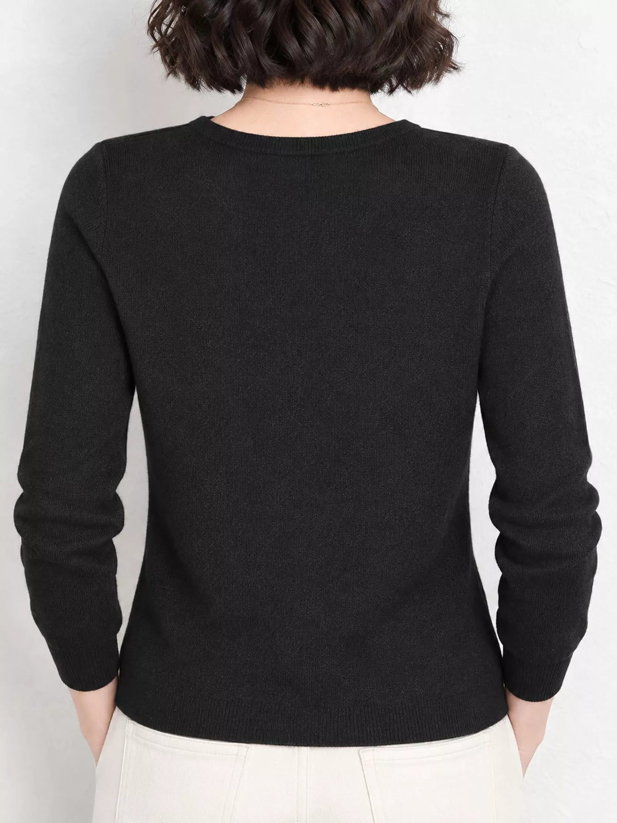 Black v-neck long sleeve knit top, back view
