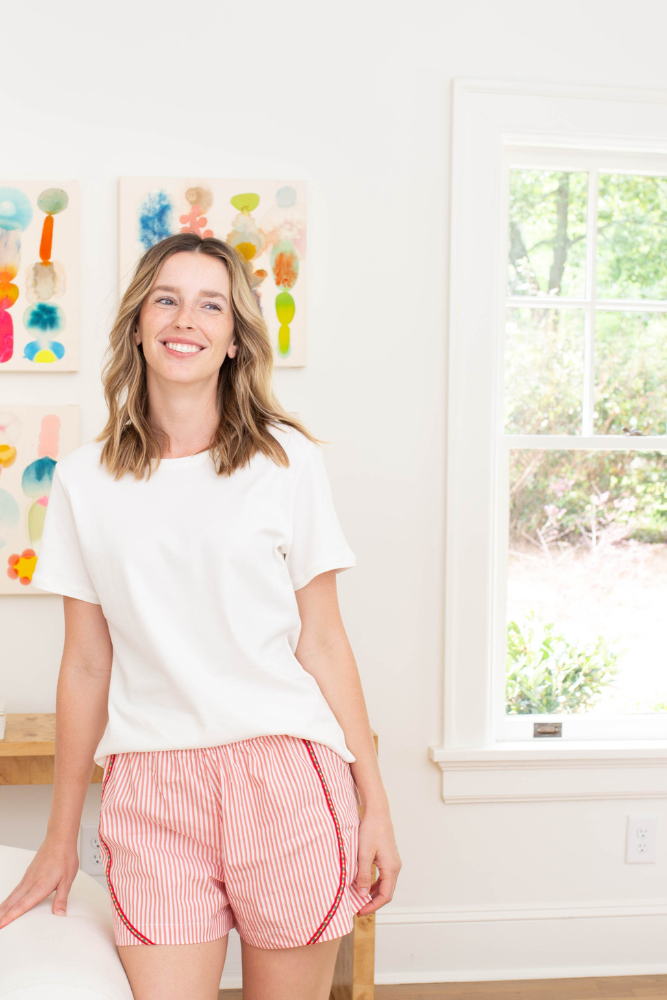 White tee and magenta-striped poplin shorts pajama set, seated view
