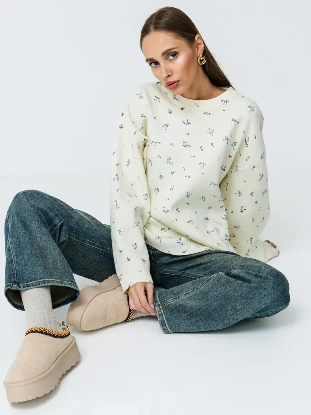 White floral dropped-shoulder oversized sweater, seated full view.