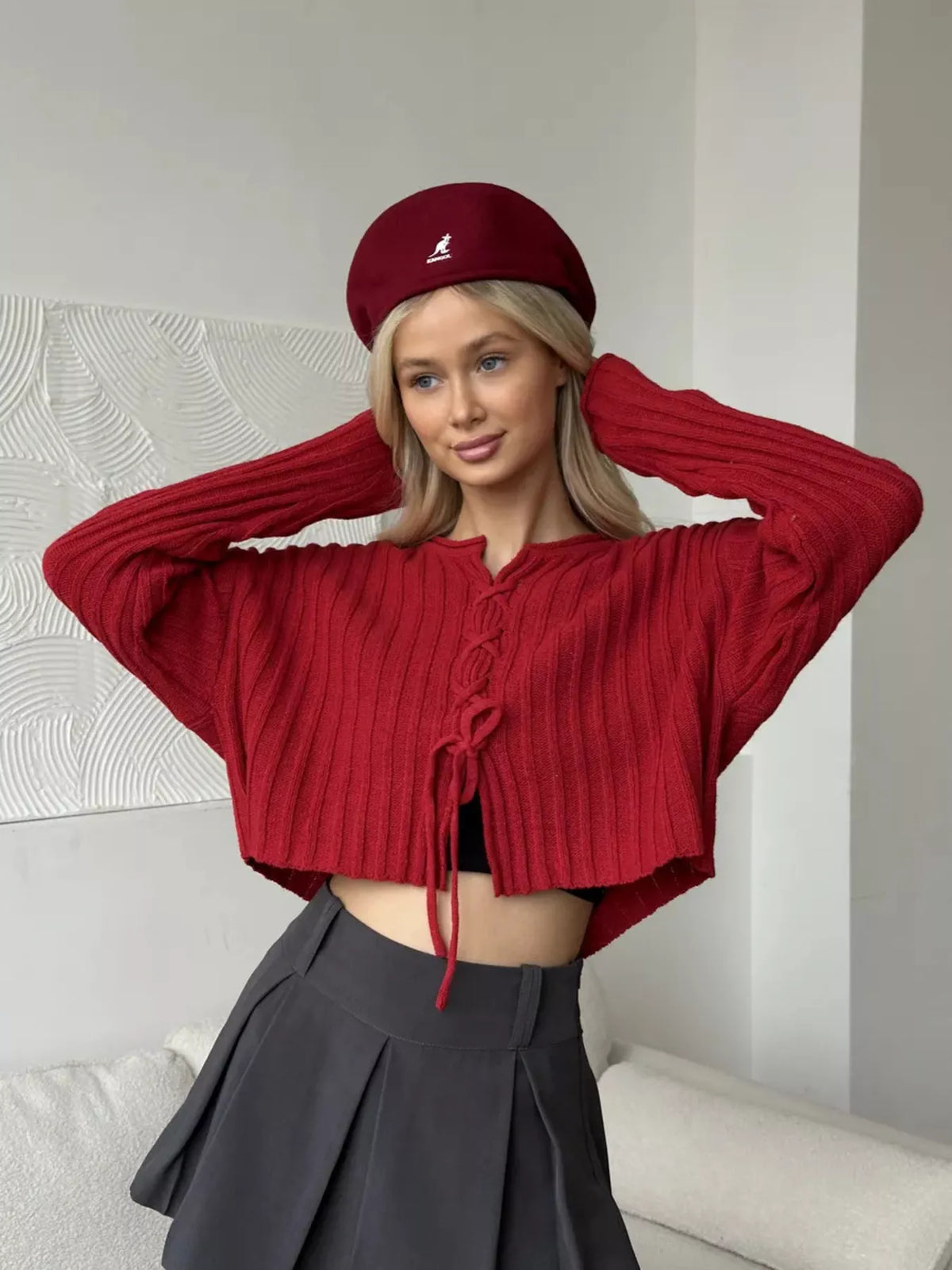 Red ribbed lace-up cropped sweater, front with arms raised.