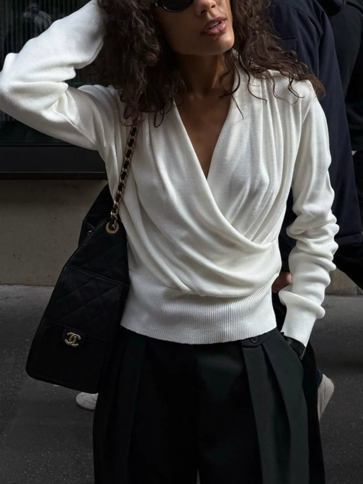 White wrap-front sweater, front view with arm raised