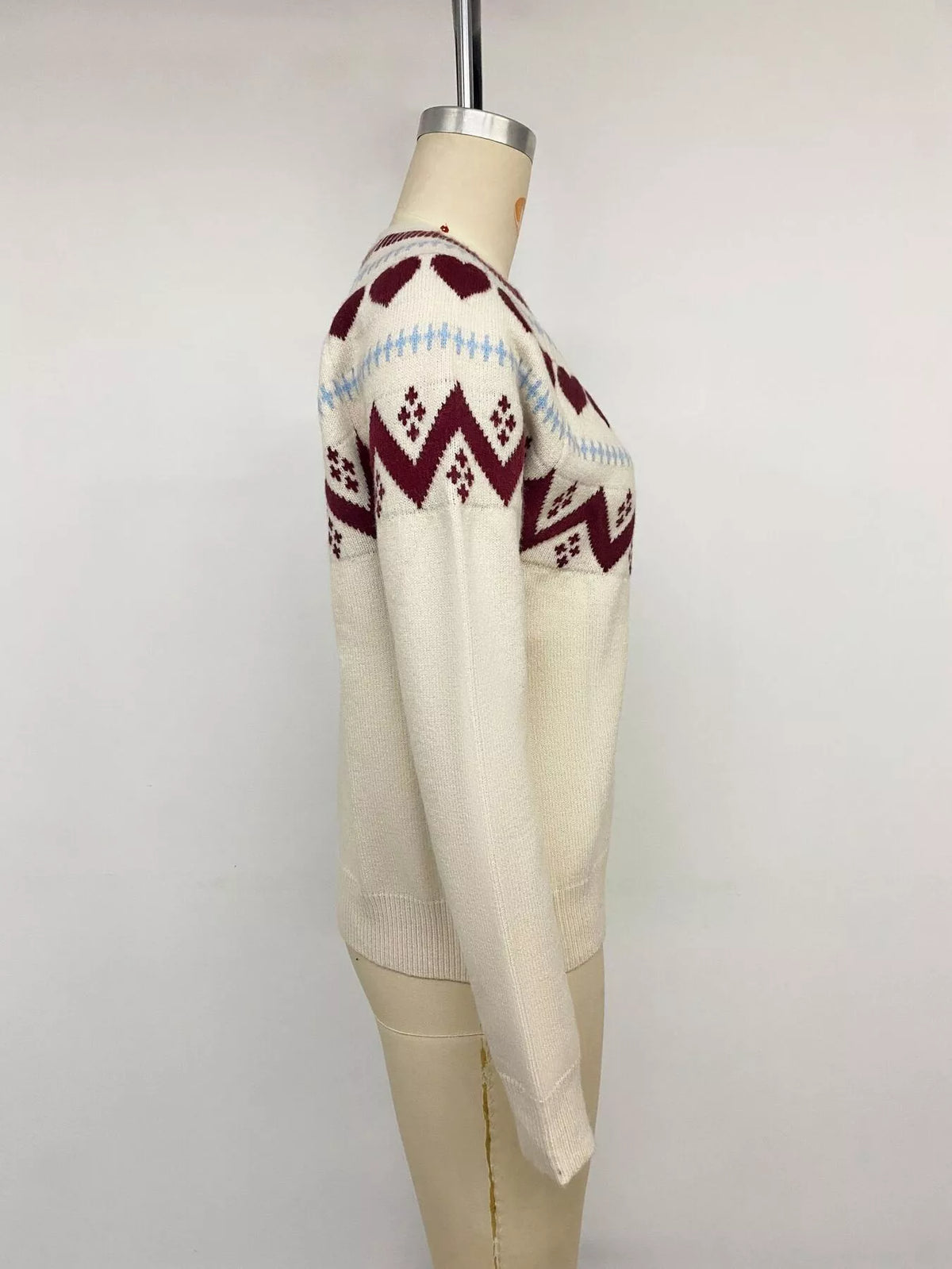 Cream heart-patterned crew neck sweater, side on mannequin