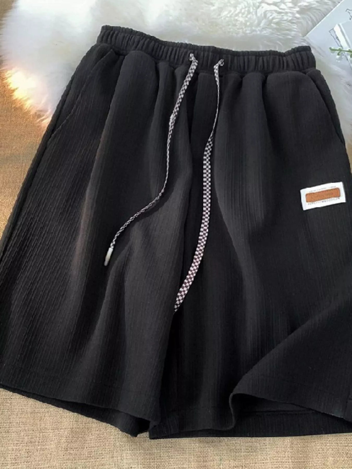 Women's Textured Drawstring Casual Shorts in black — flat lay view