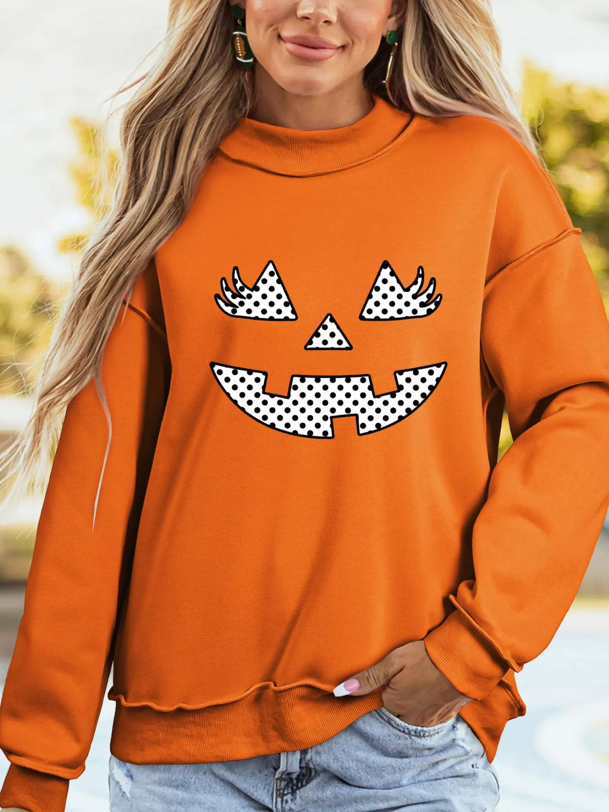 Women's Polka Dot Pumpkin Face Halloween Graphic Pullover Sweatshirt in Orange, front view