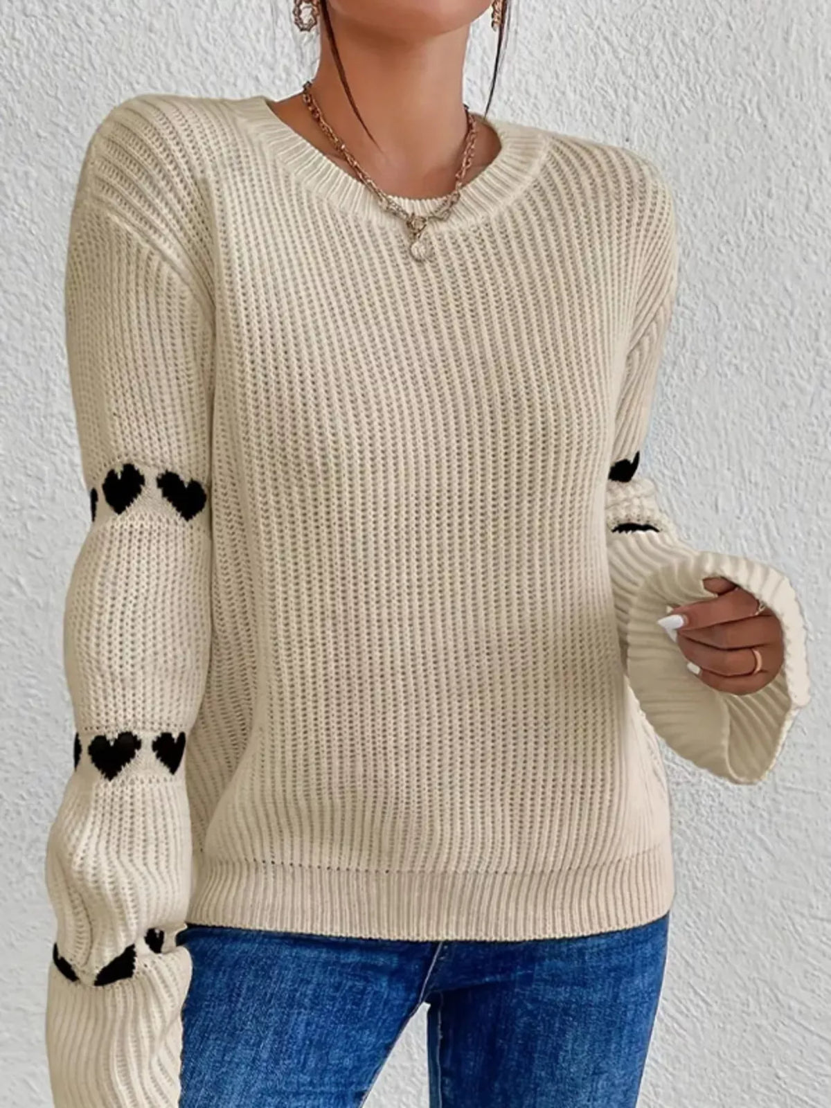 Beige and black heart-sleeve dropped-shoulder sweater, front view.